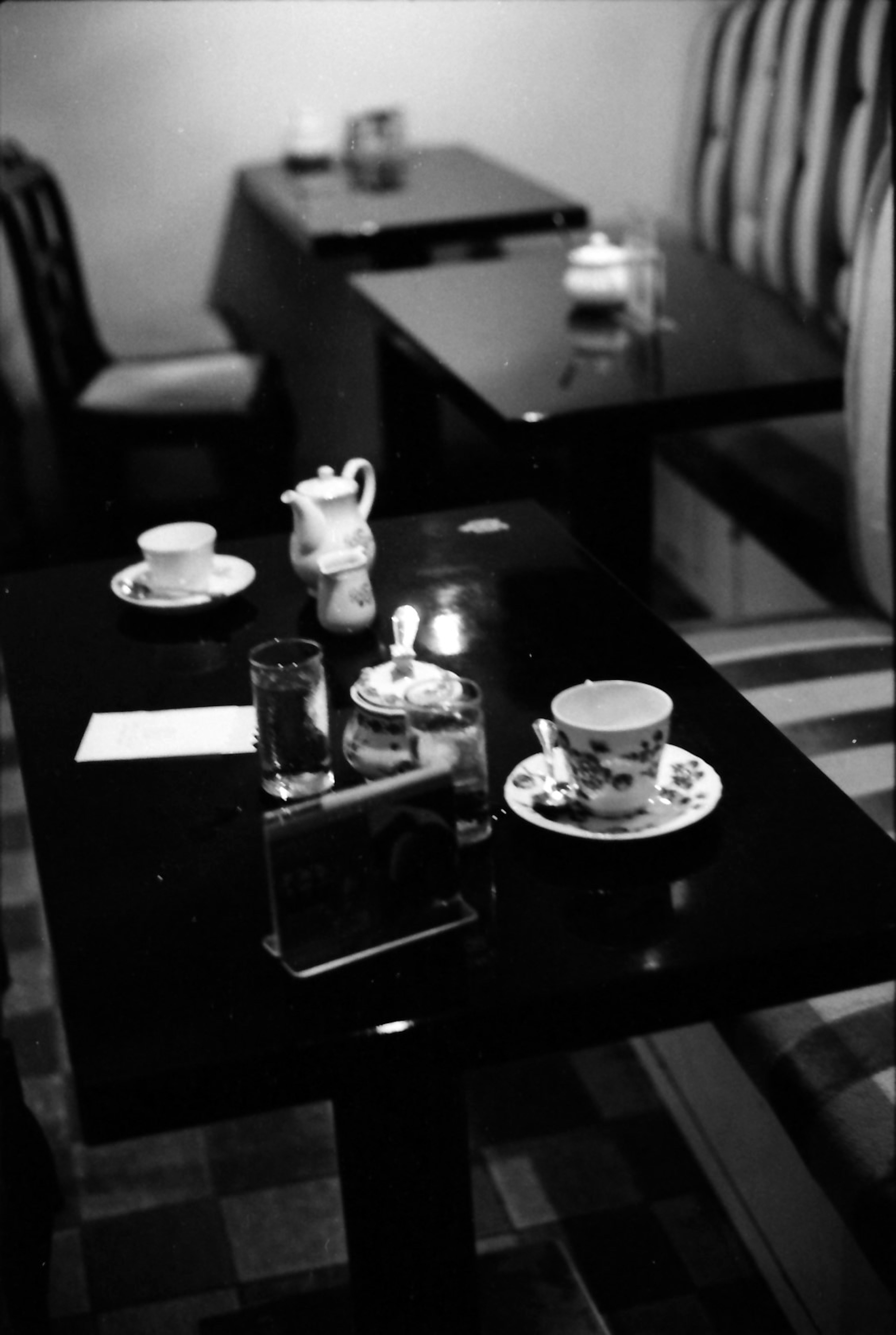 Table de café en noir et blanc avec service à thé et pâtisseries