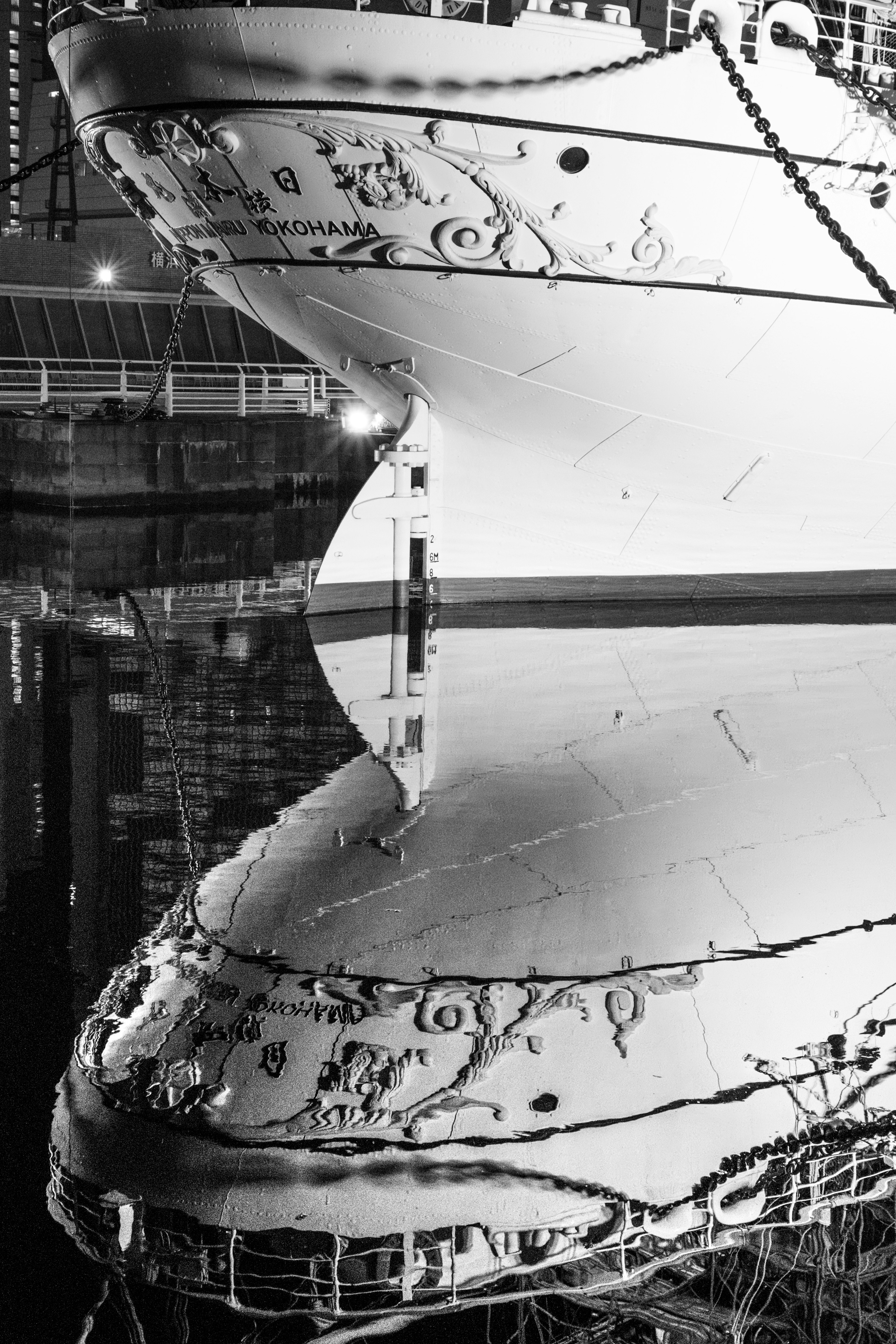 White ship bow reflected on water with decorative design