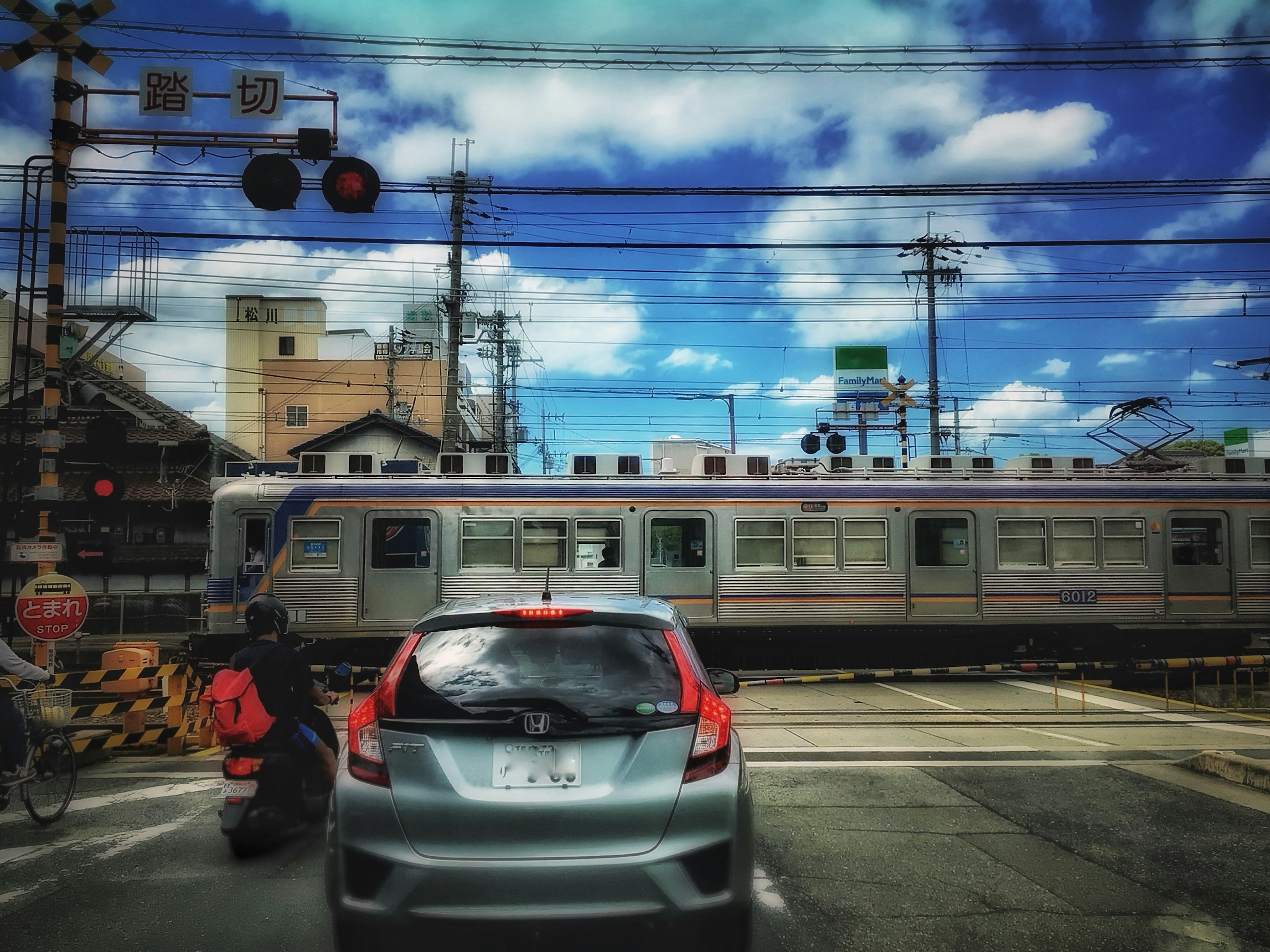 Szene eines Bahnübergangs mit einem vorbeifahrenden Zug und blauem Himmel