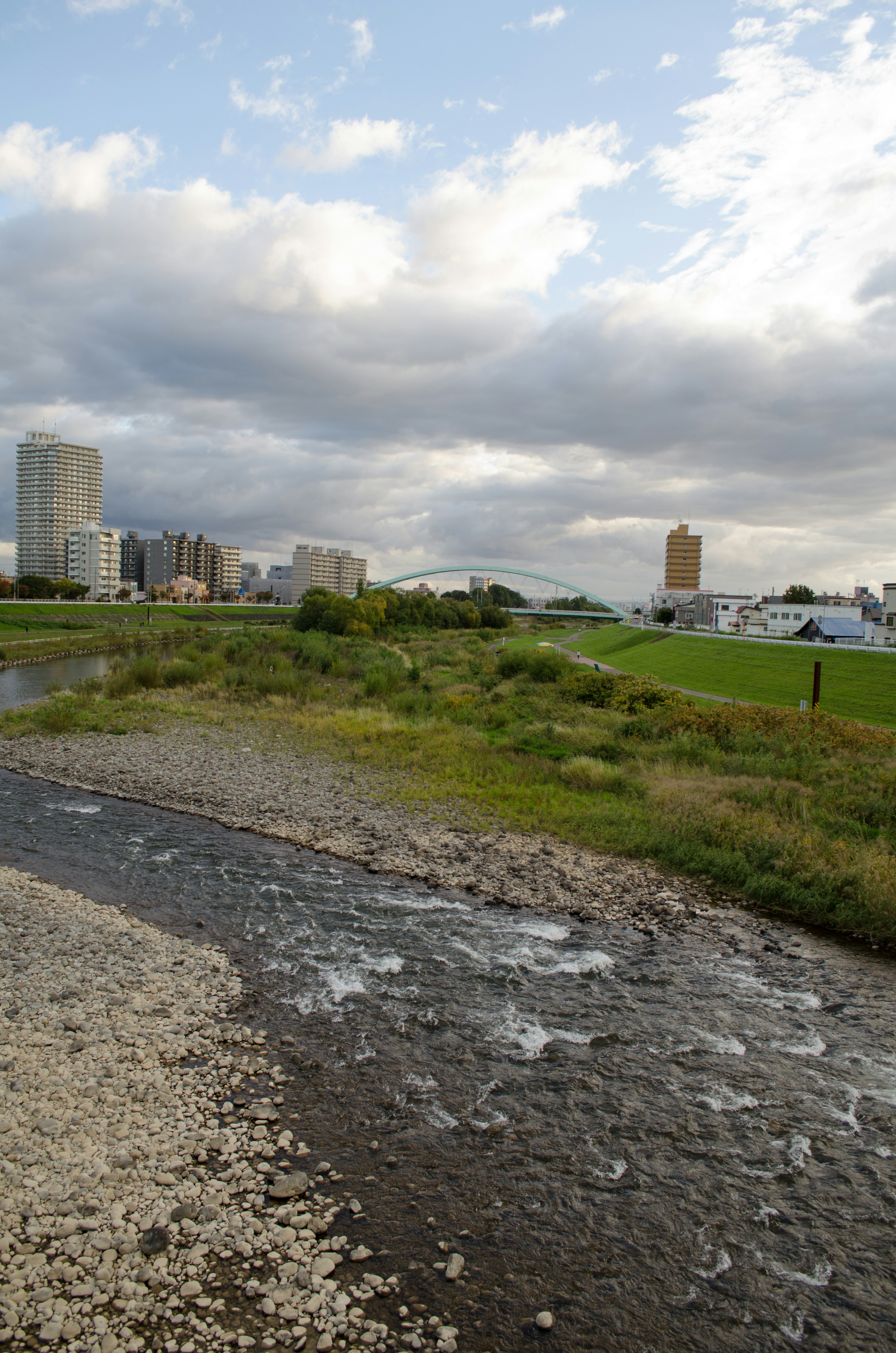 Río fluyendo con el horizonte de la ciudad al fondo