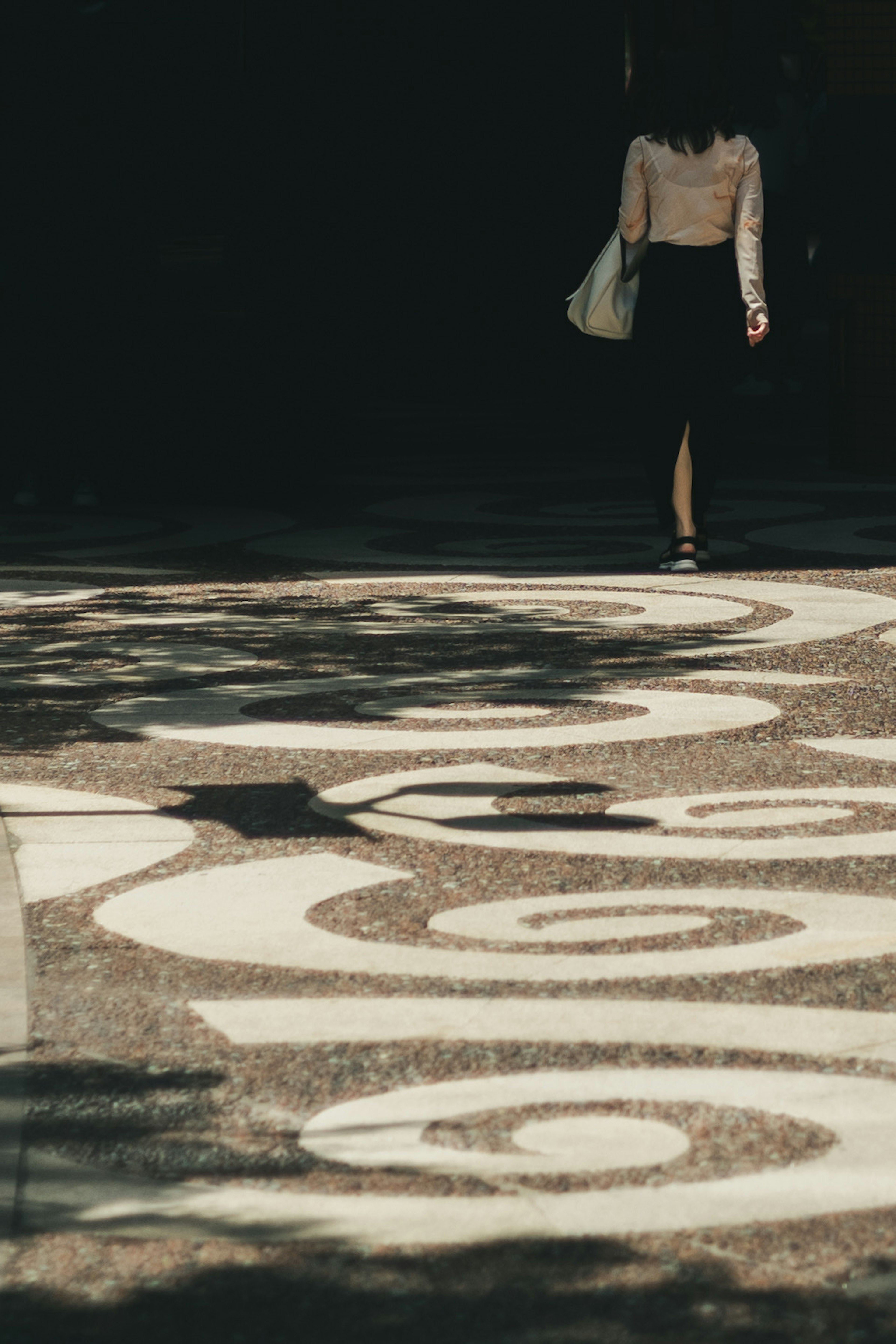 Una mujer caminando sobre una acera con patrones