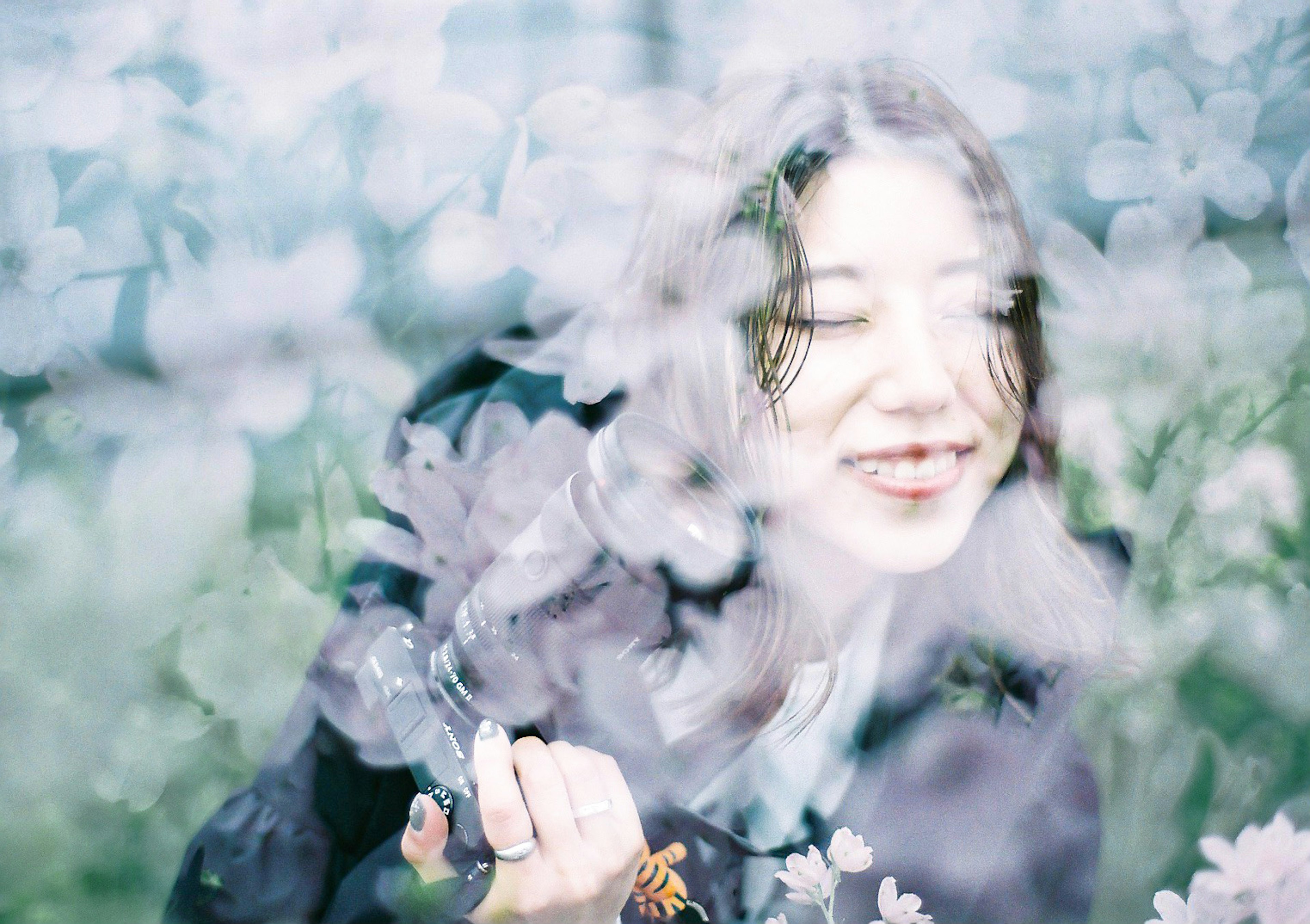 Una mujer sonriendo entre flores con un efecto de desenfoque suave