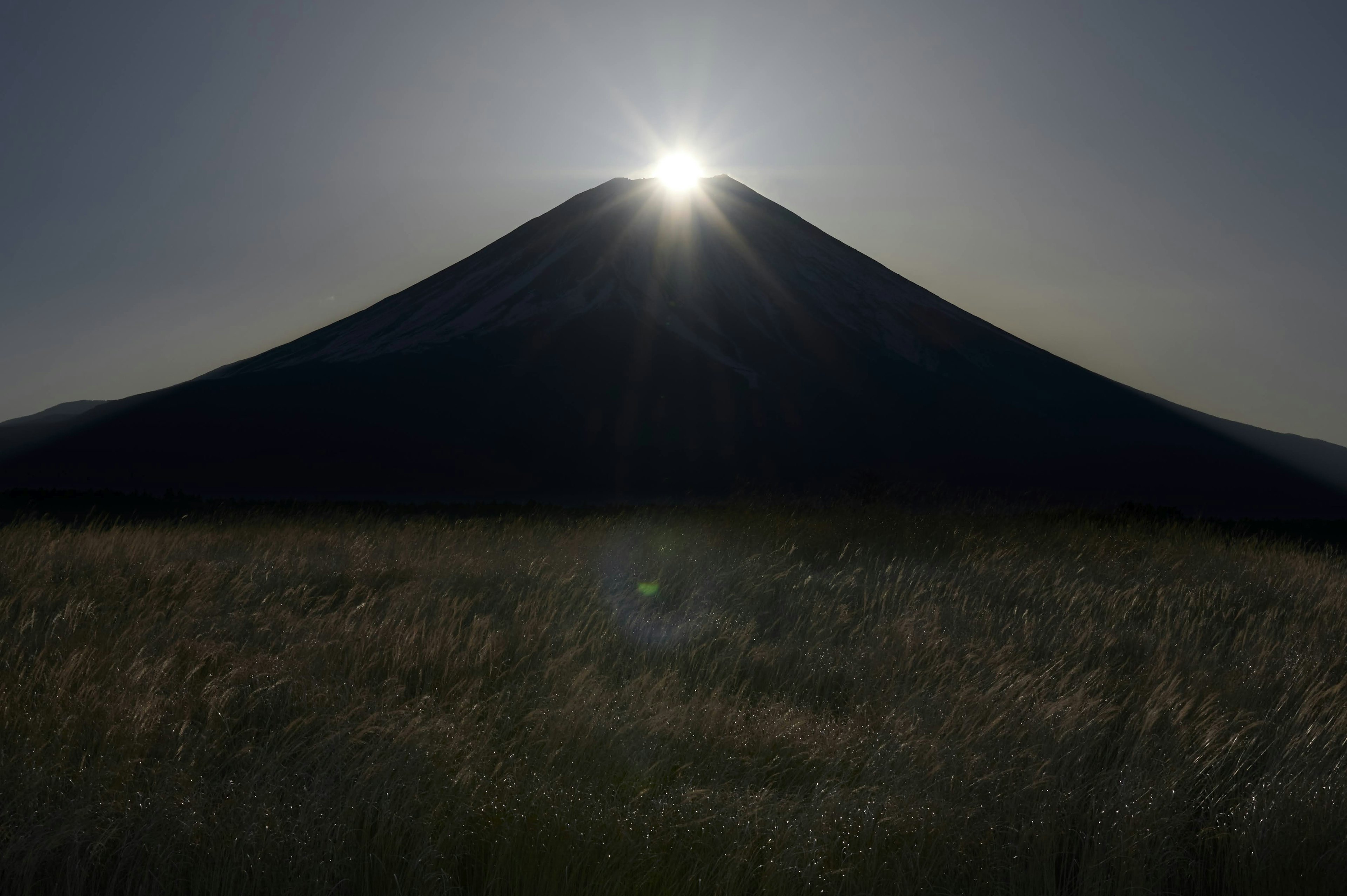 美しい富士山のシルエットとその上に輝く太陽