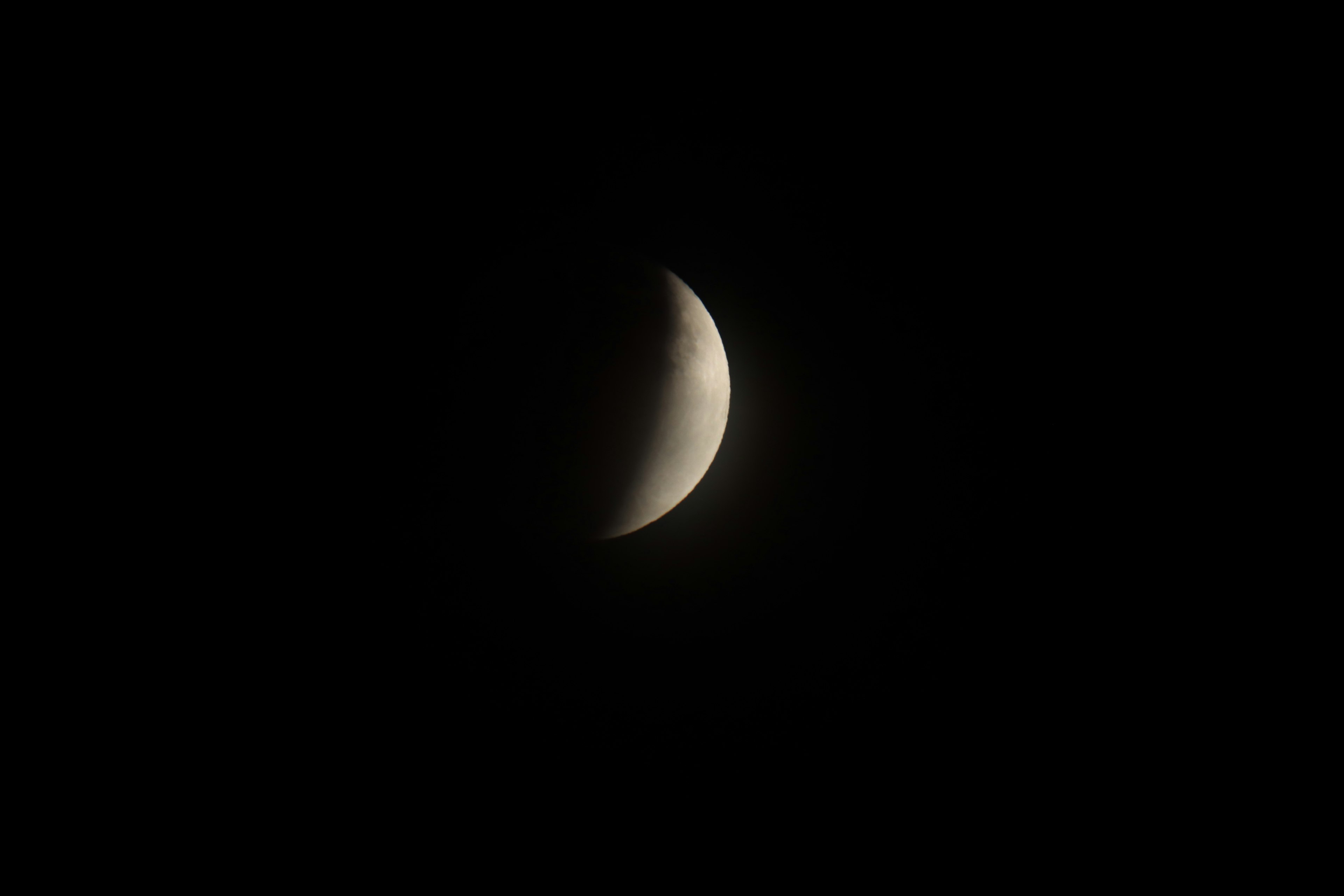 Luna creciente iluminada sobre un fondo oscuro