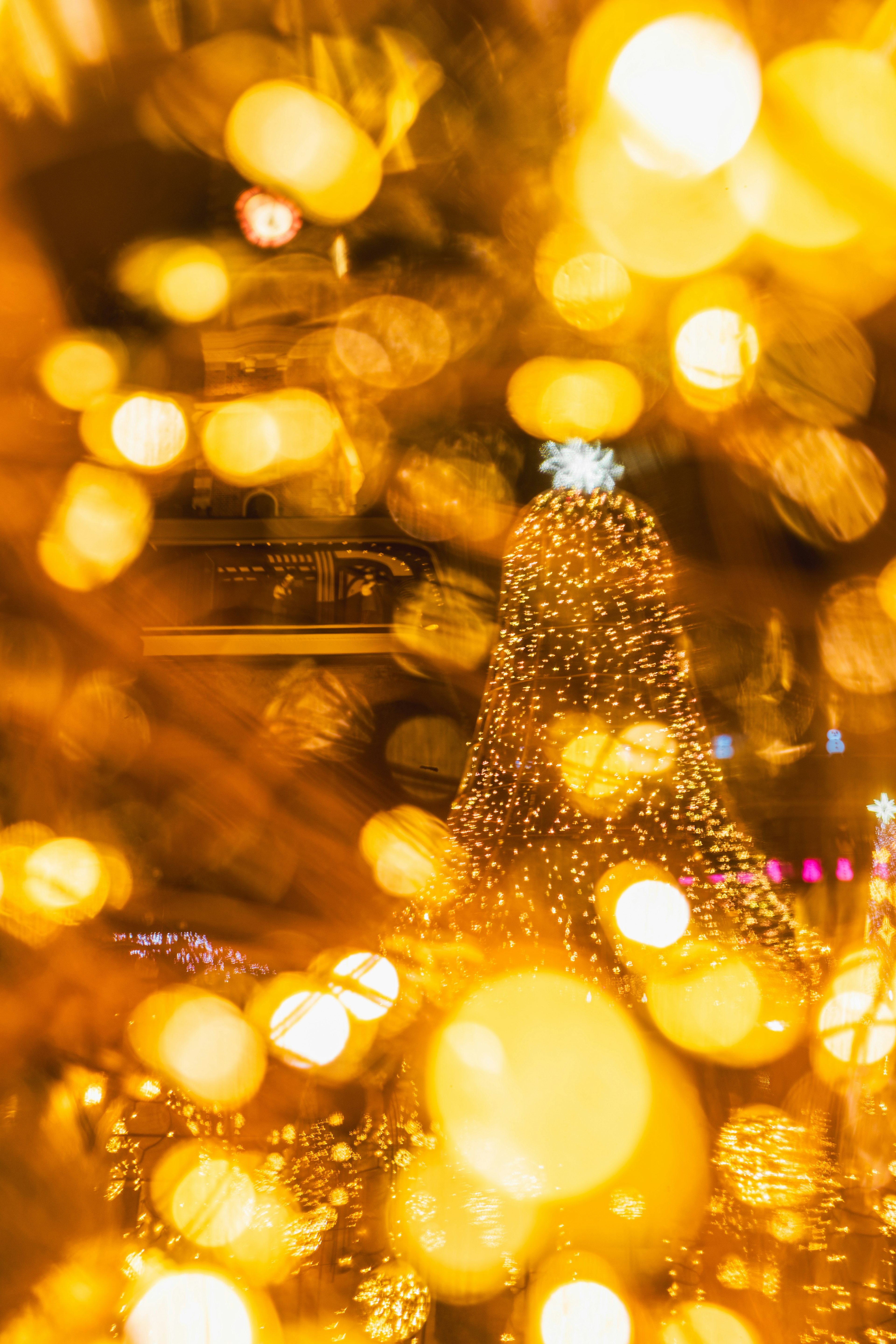 Blurred Christmas tree illuminated by golden lights