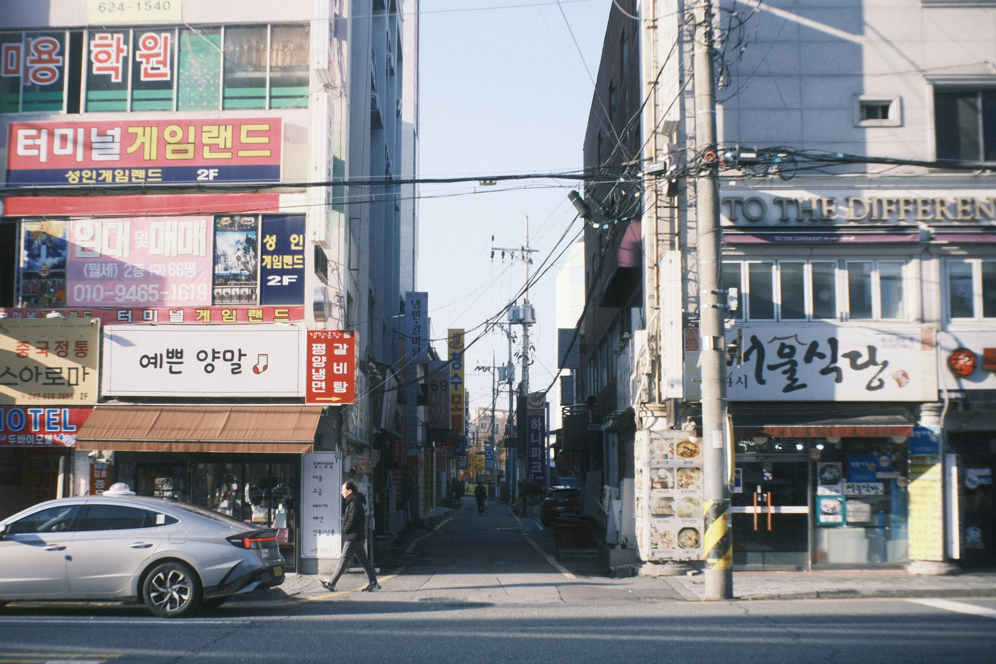 Pemandangan jalan di Korea Selatan dengan toko-toko dan mobil yang lewat