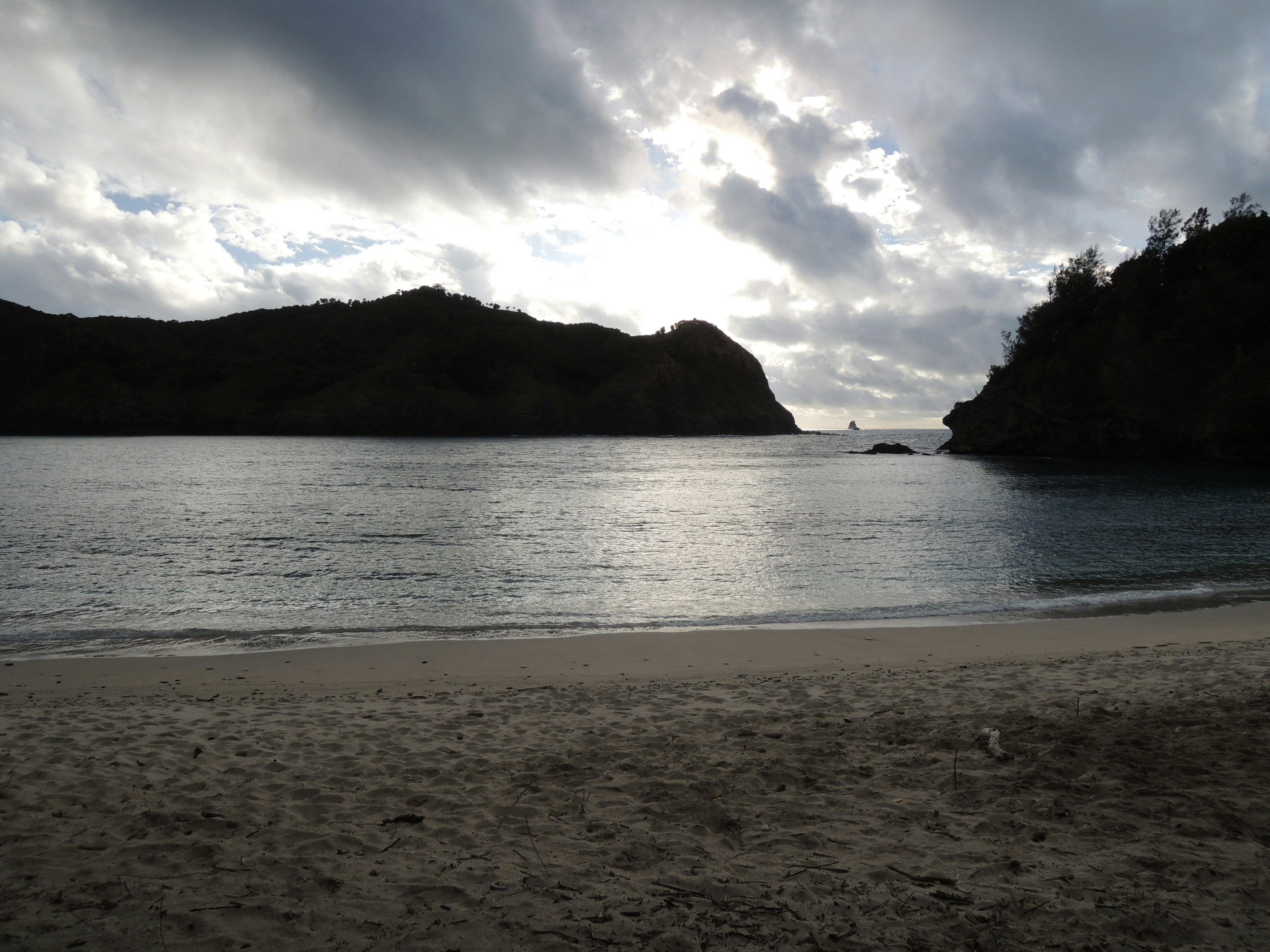 Scena di spiaggia serena con mare calmo e nuvole scure in lontananza