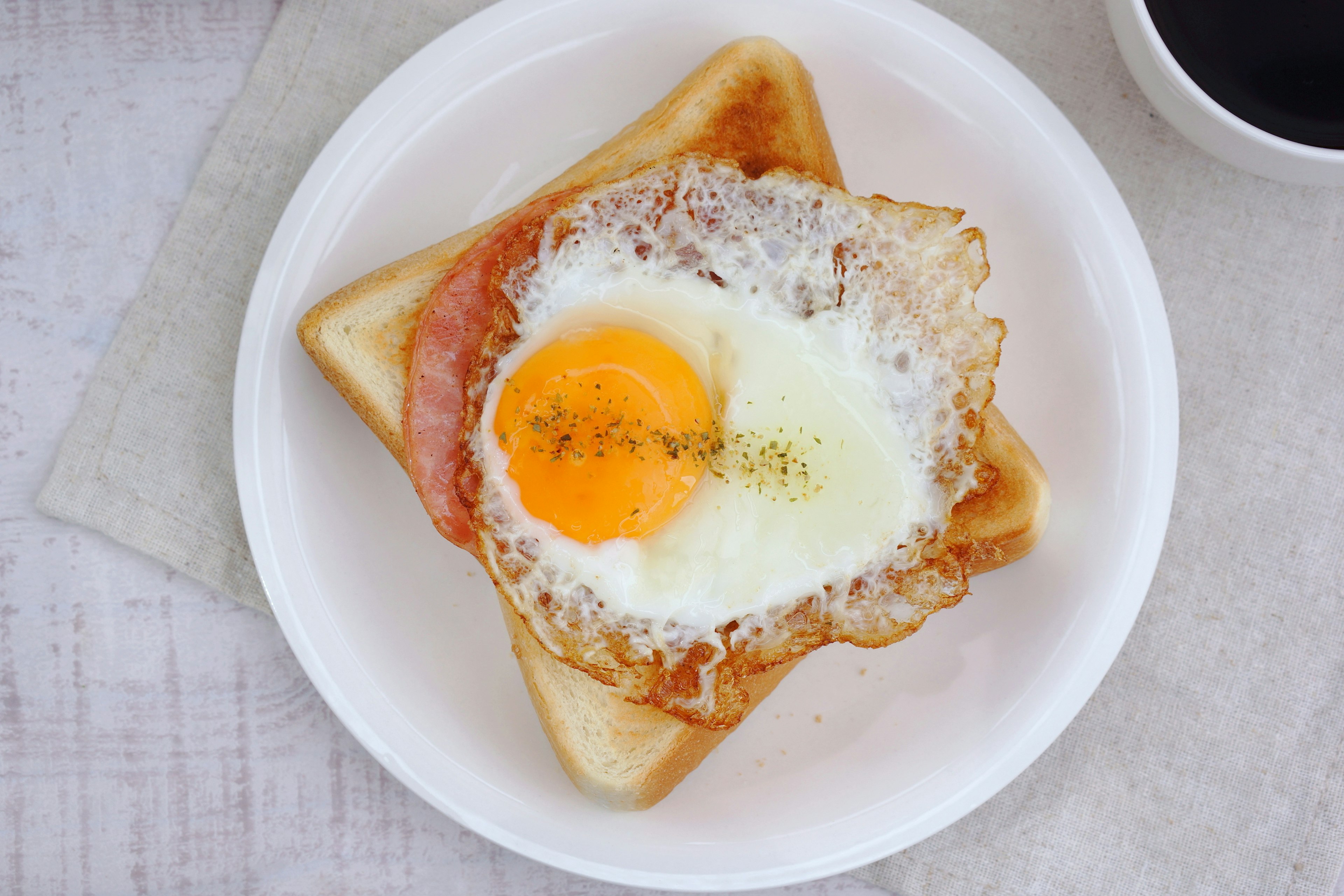 Frühstück mit Toast belegt mit Schinken und einem Spiegelei