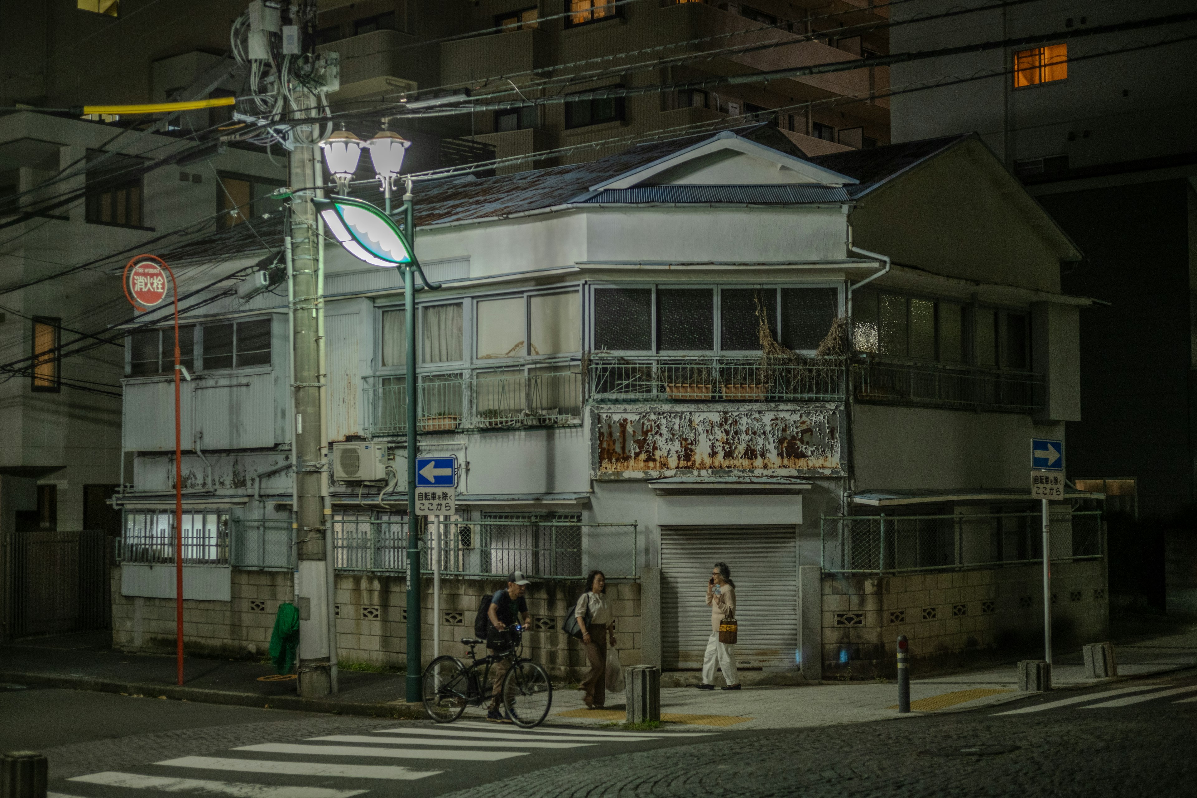 Casa blanca en una esquina de la calle por la noche con farola