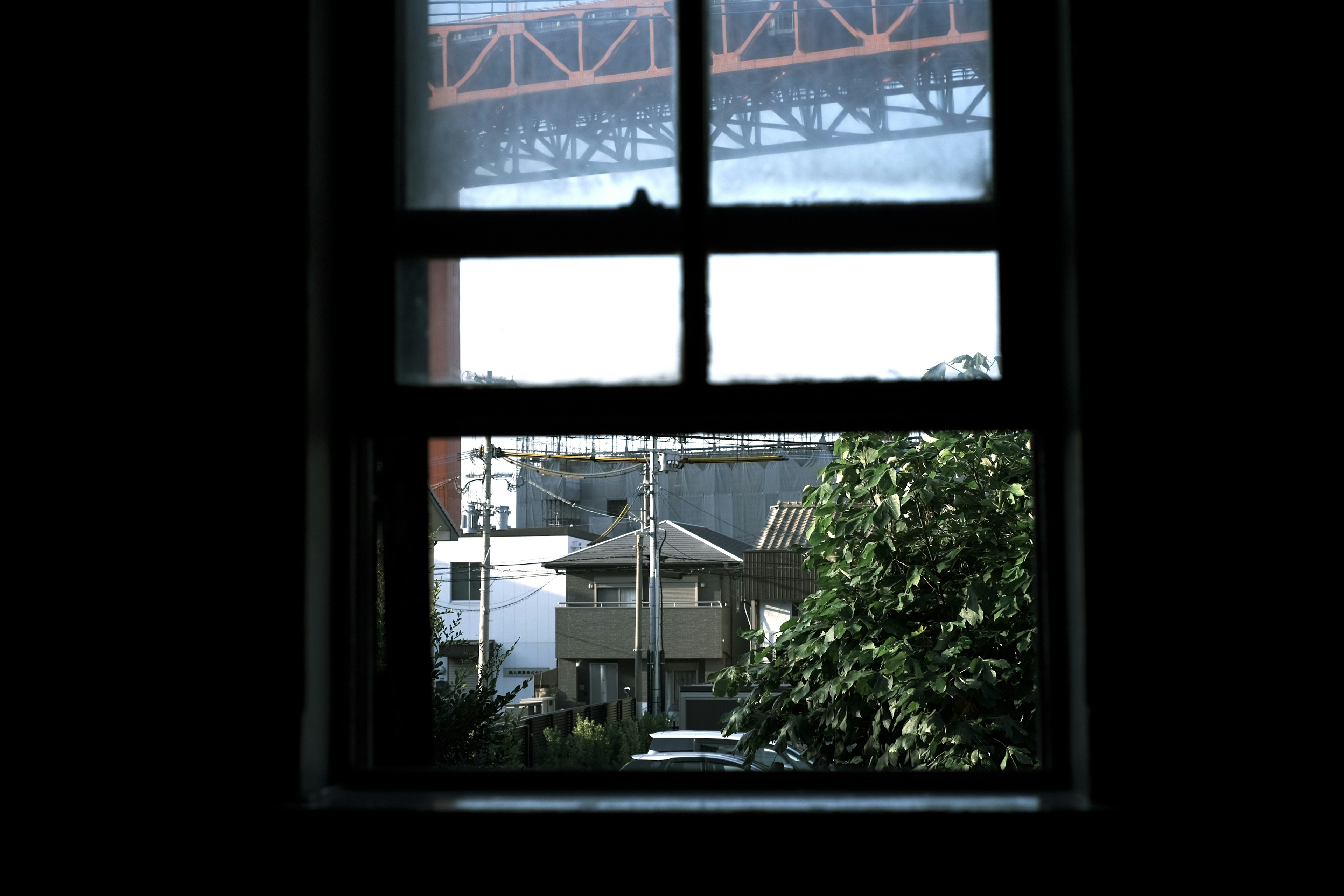 Blick auf Häuser und Grün durch ein Fenster