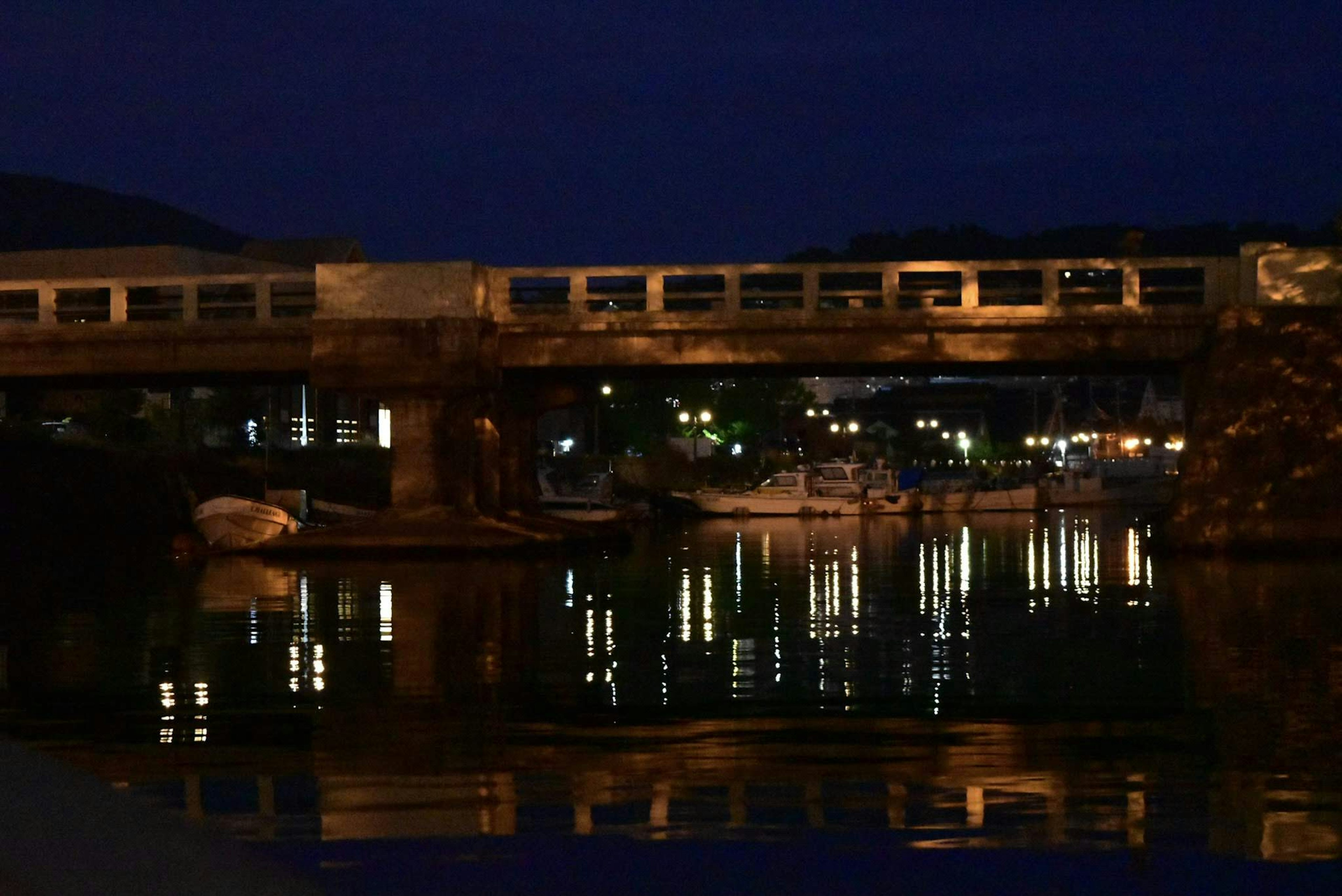 夜の川に映る橋と街灯の光