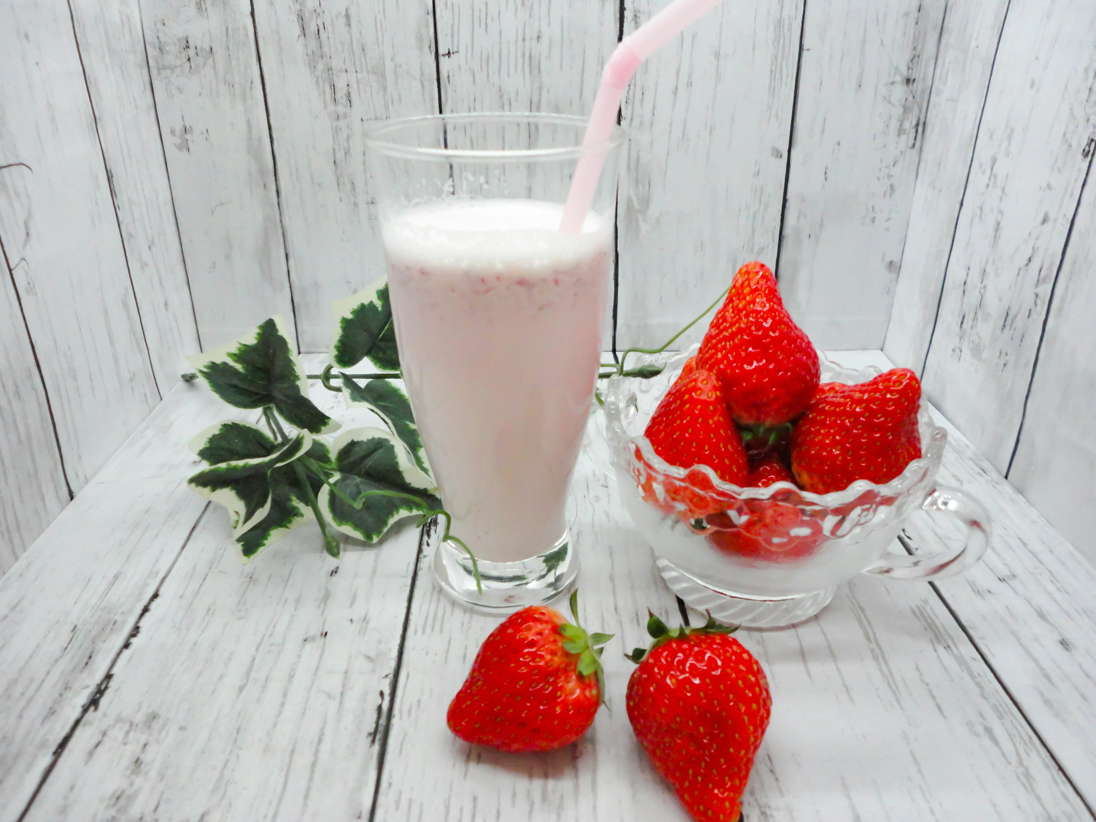 Strawberry shake with fresh strawberries on a wooden table