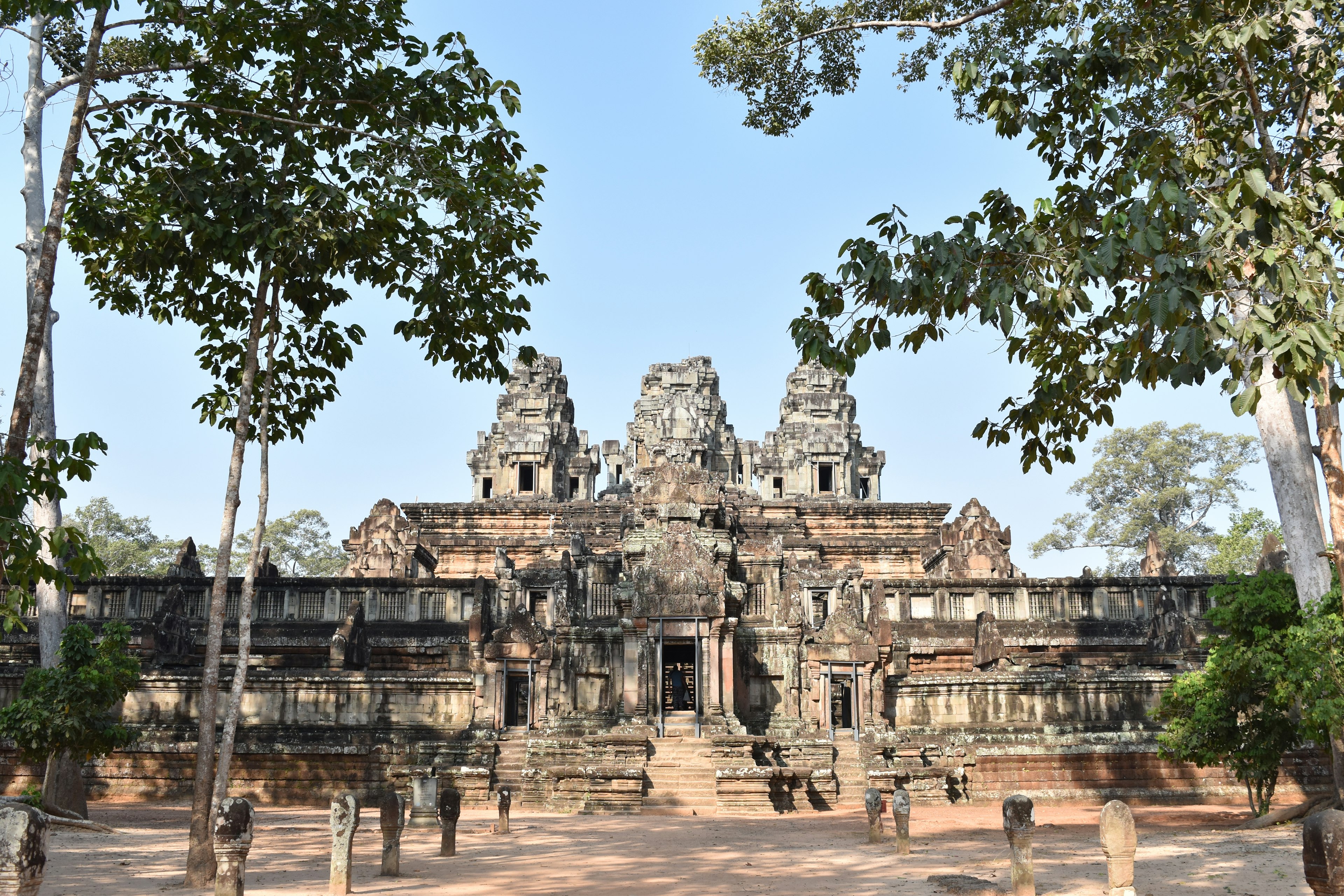 Majestic view of an ancient Cambodian temple surrounded by lush trees and stone architecture