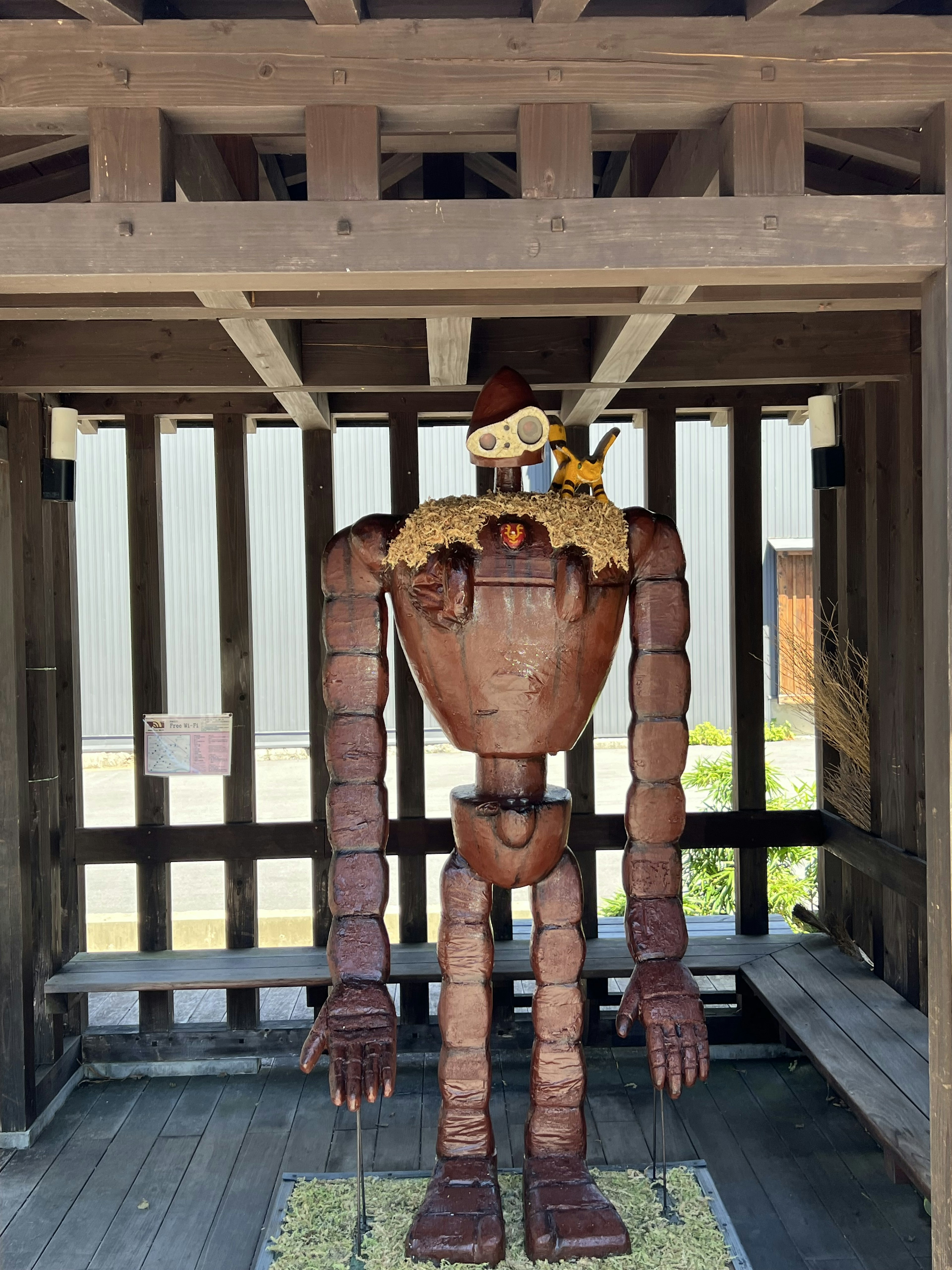 Wooden robot standing in an outdoor structure