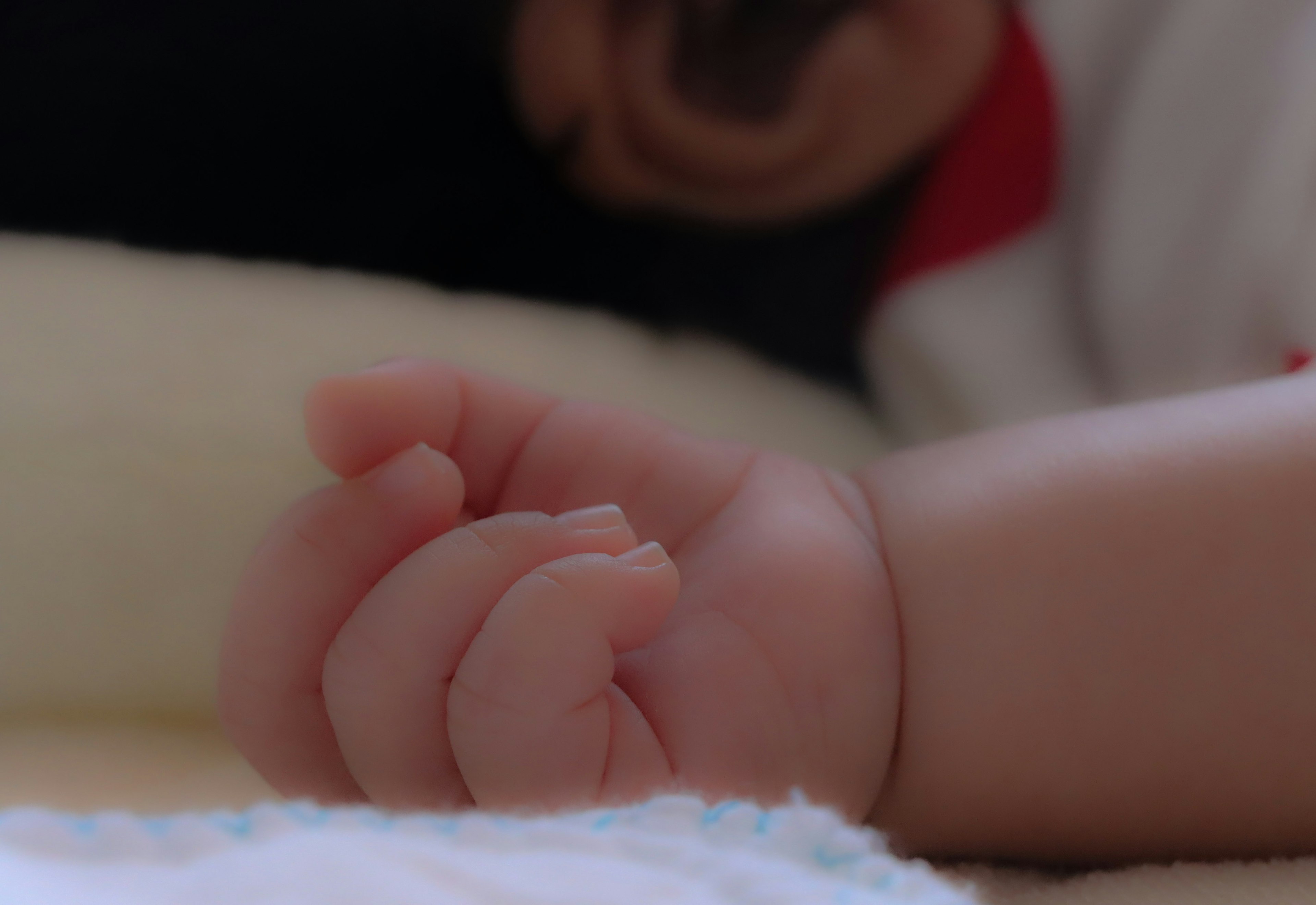 A baby's hand resting on soft fabric