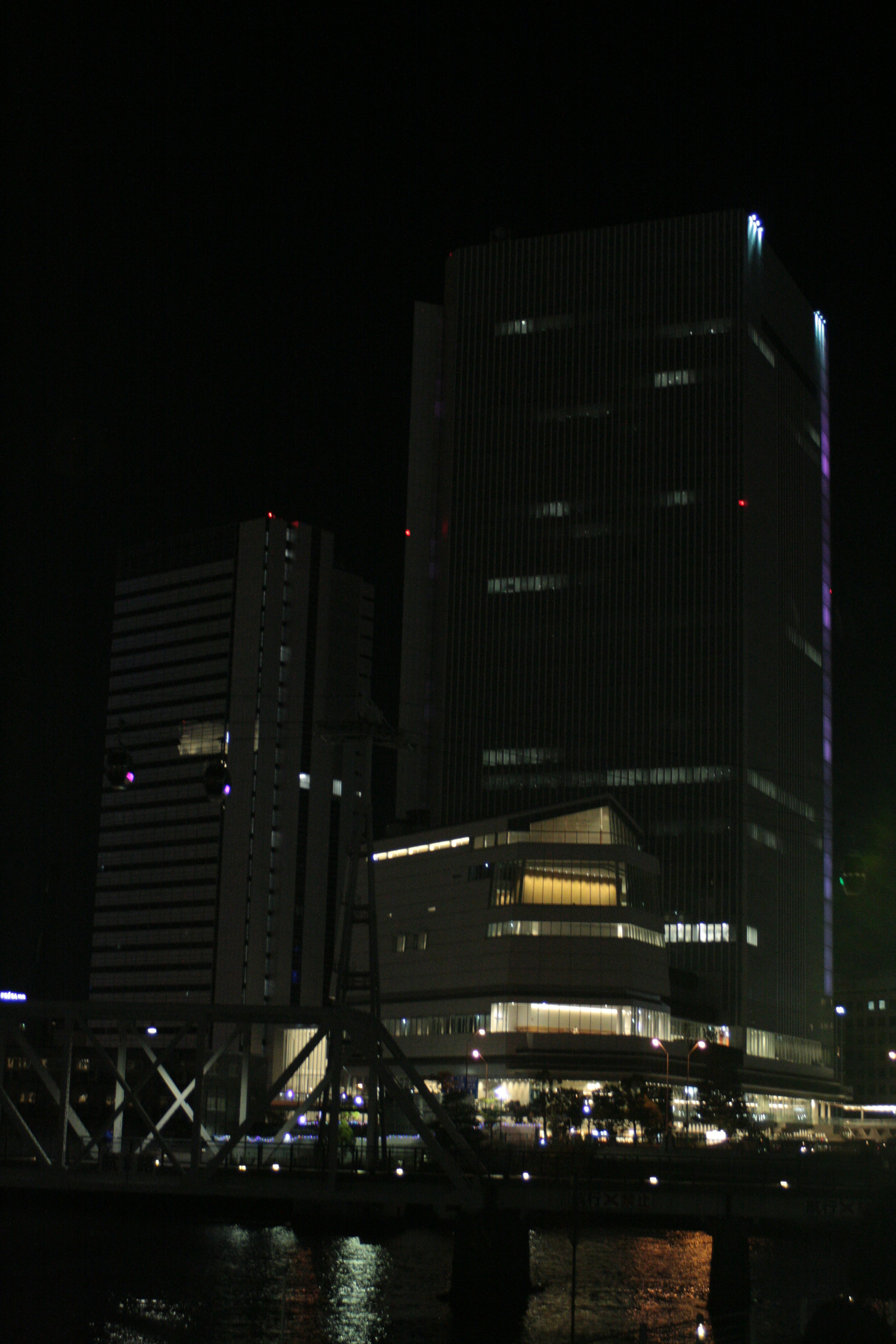 夜の都市景観にそびえる高層ビル群が見える