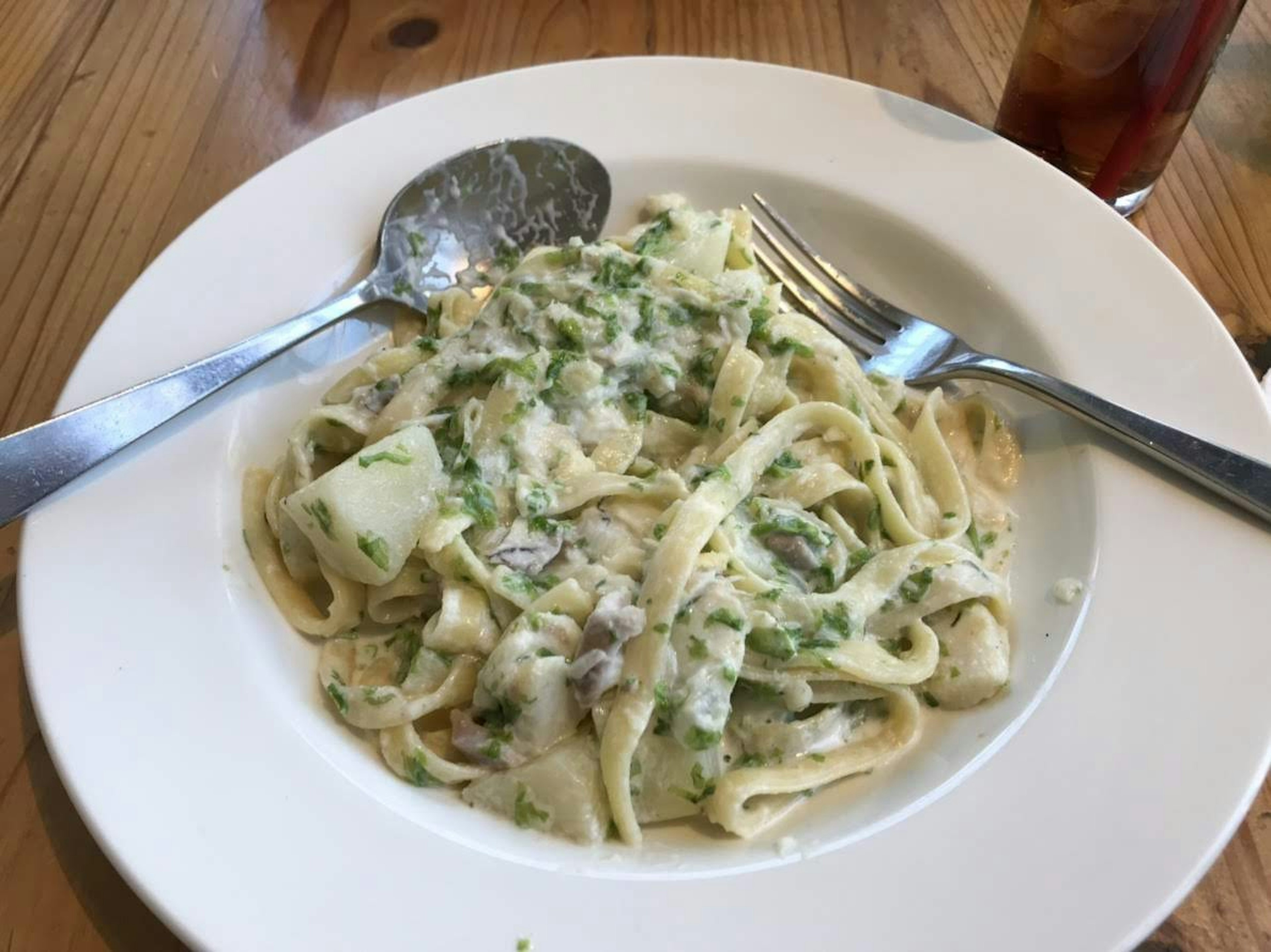 Piatto di pasta cremosa guarnito con prezzemolo su un piatto bianco