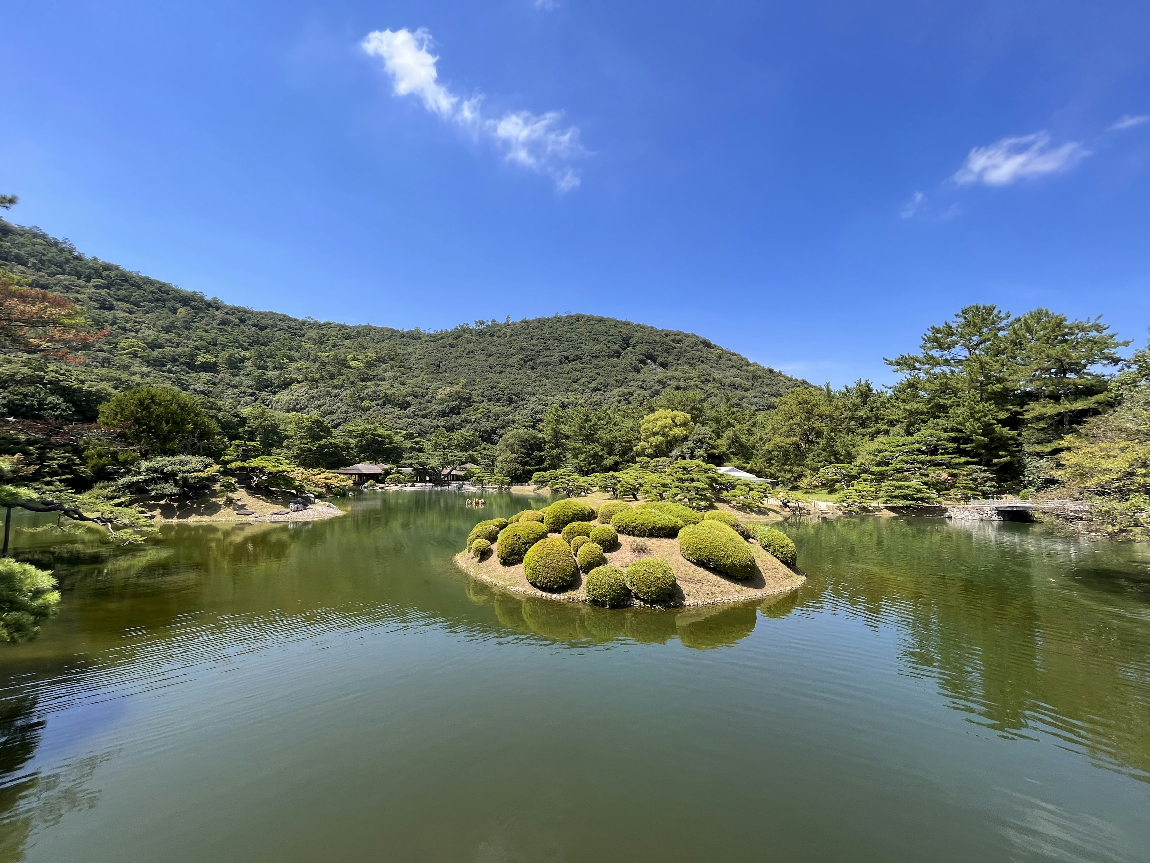 静かな池と緑豊かな島がある日本庭園の風景