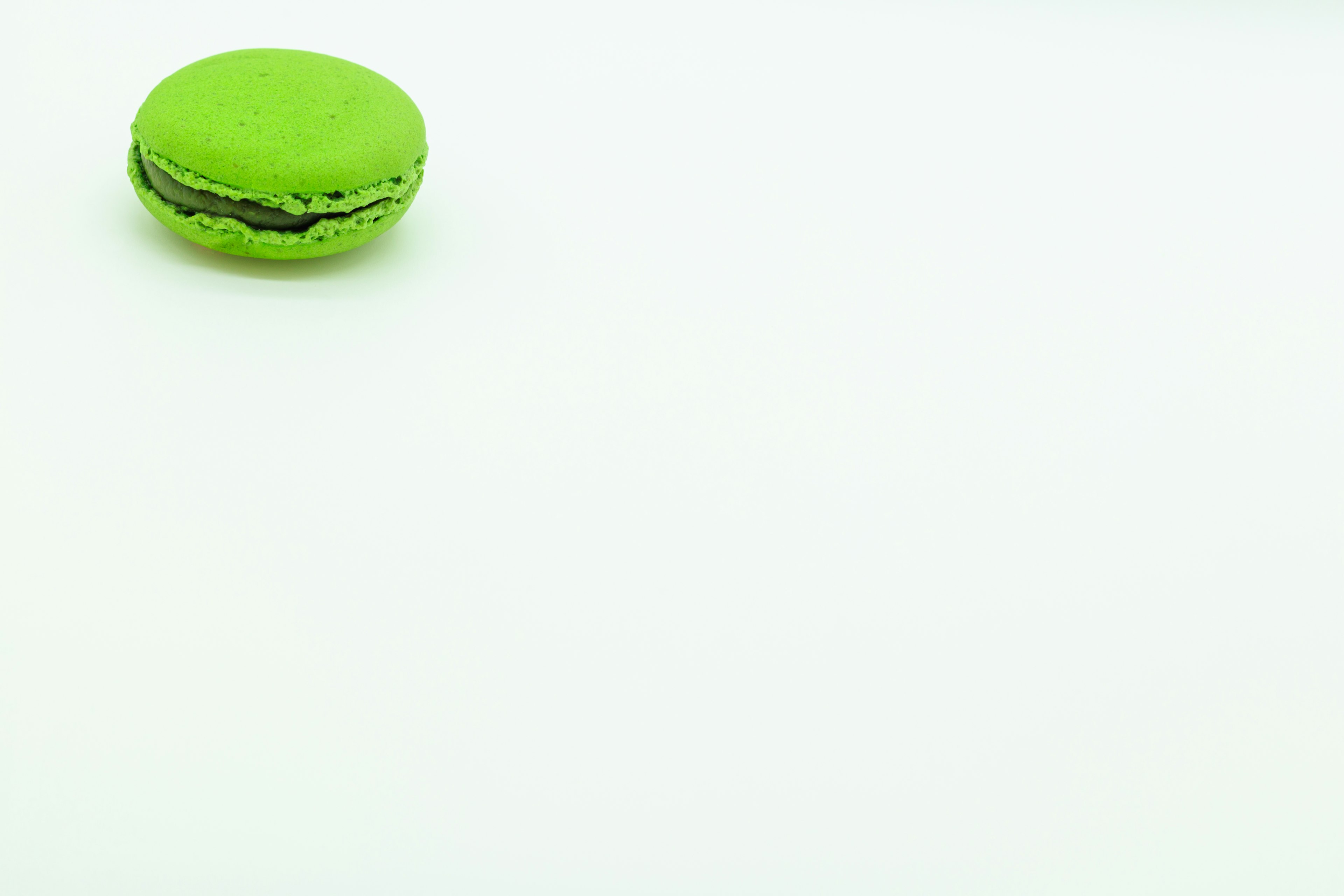 A green macaron placed on a white background