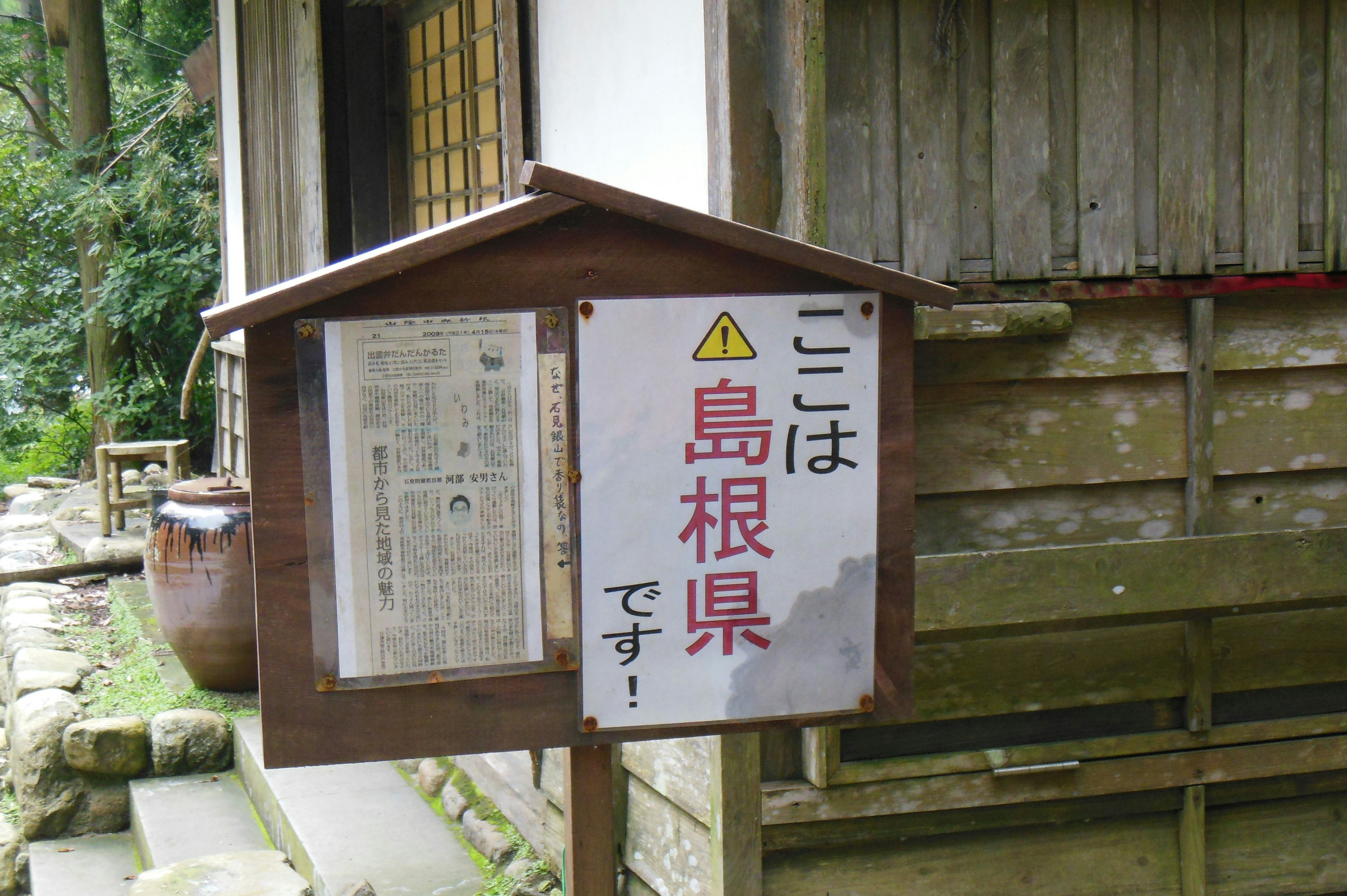 Sign indicating Shimane Prefecture next to an old building