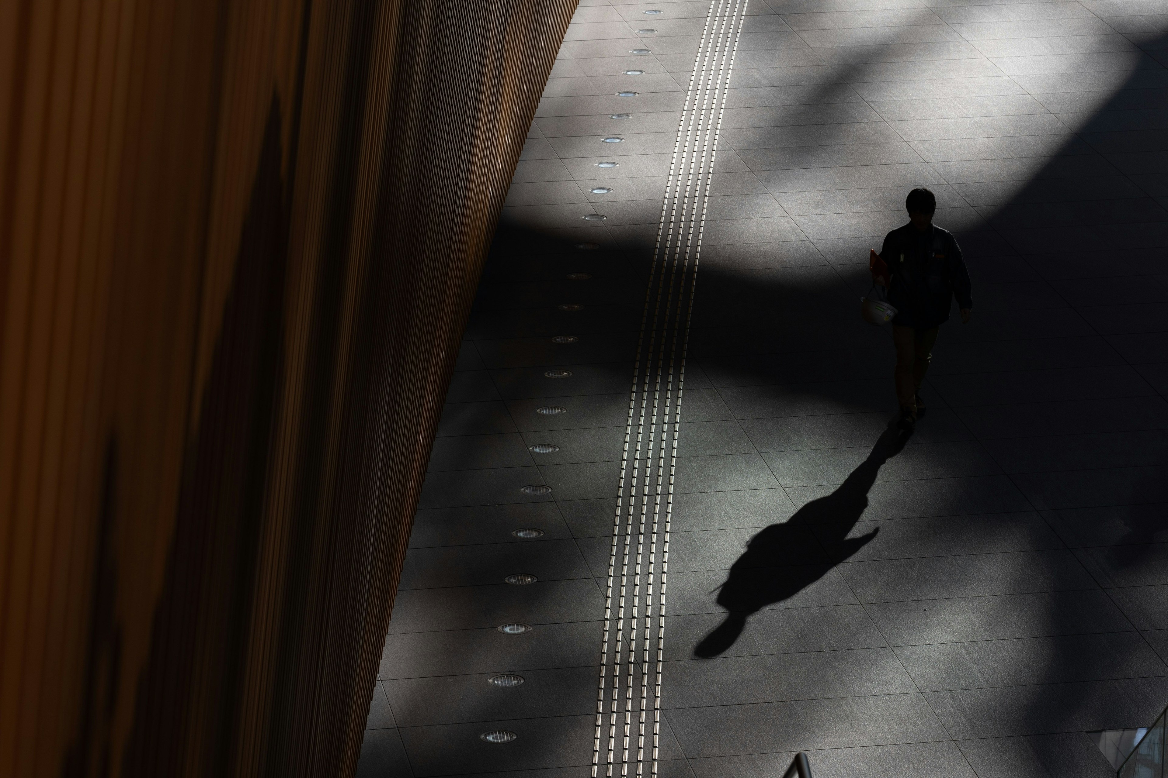 Silhouette einer Person, die im Schatten mit Lichtkontrast geht