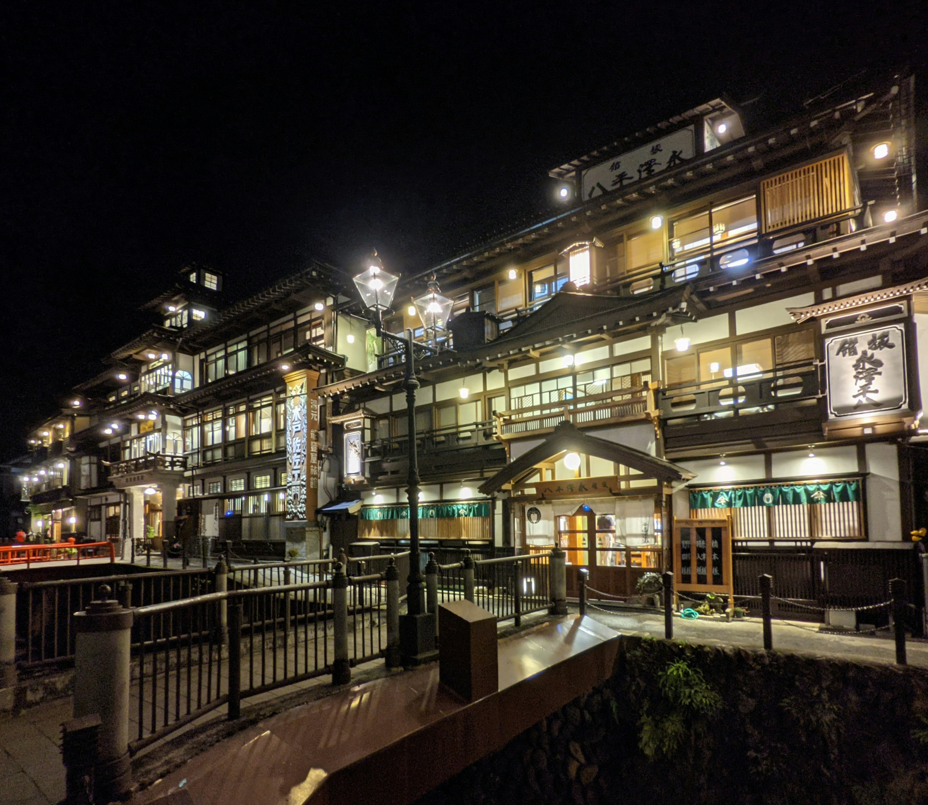 Hermosa fachada de una posada termal por la noche con luces