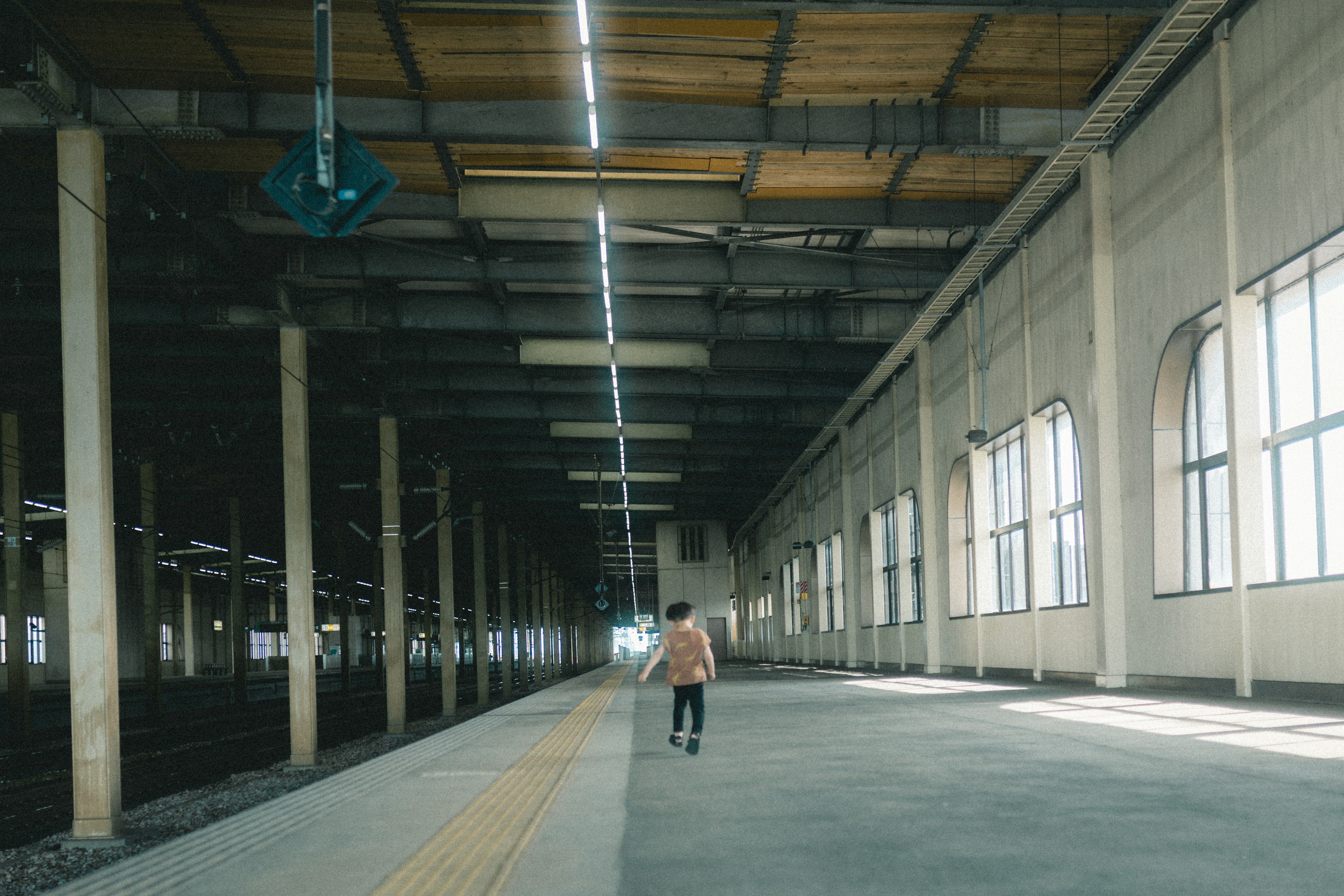 Eine Person, die auf einem geräumigen Bahnsteig steht