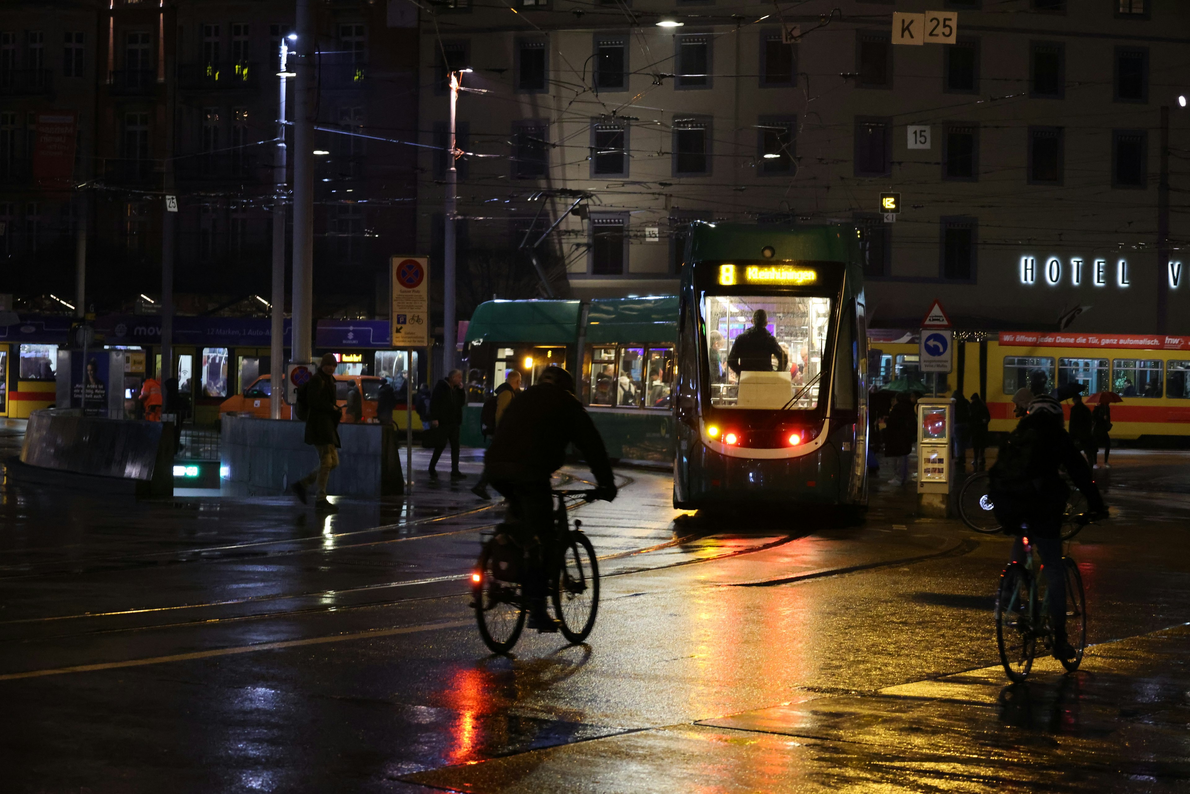 Scene of cyclists and tram lights in a city at night