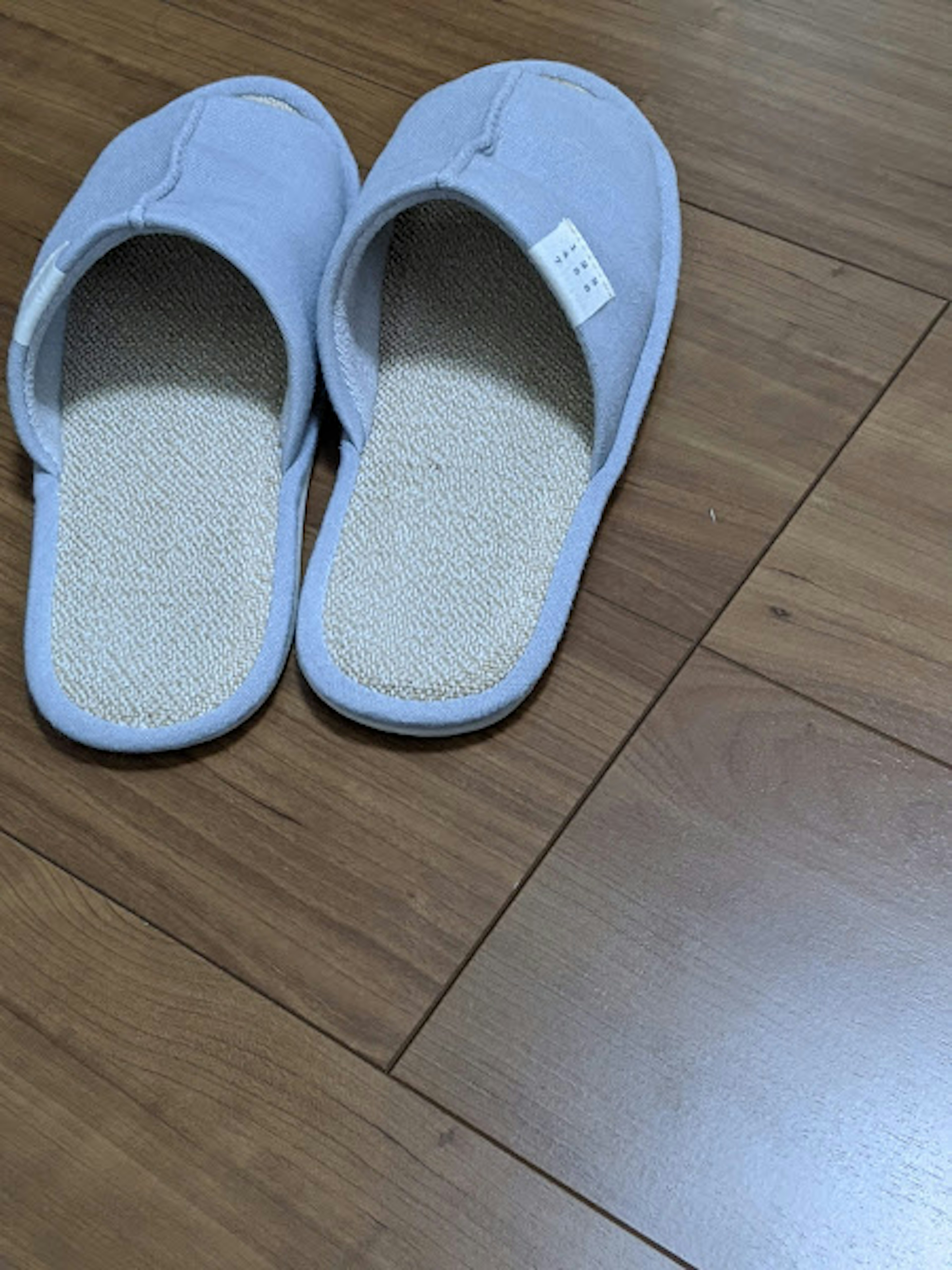 White slippers placed on wooden floor