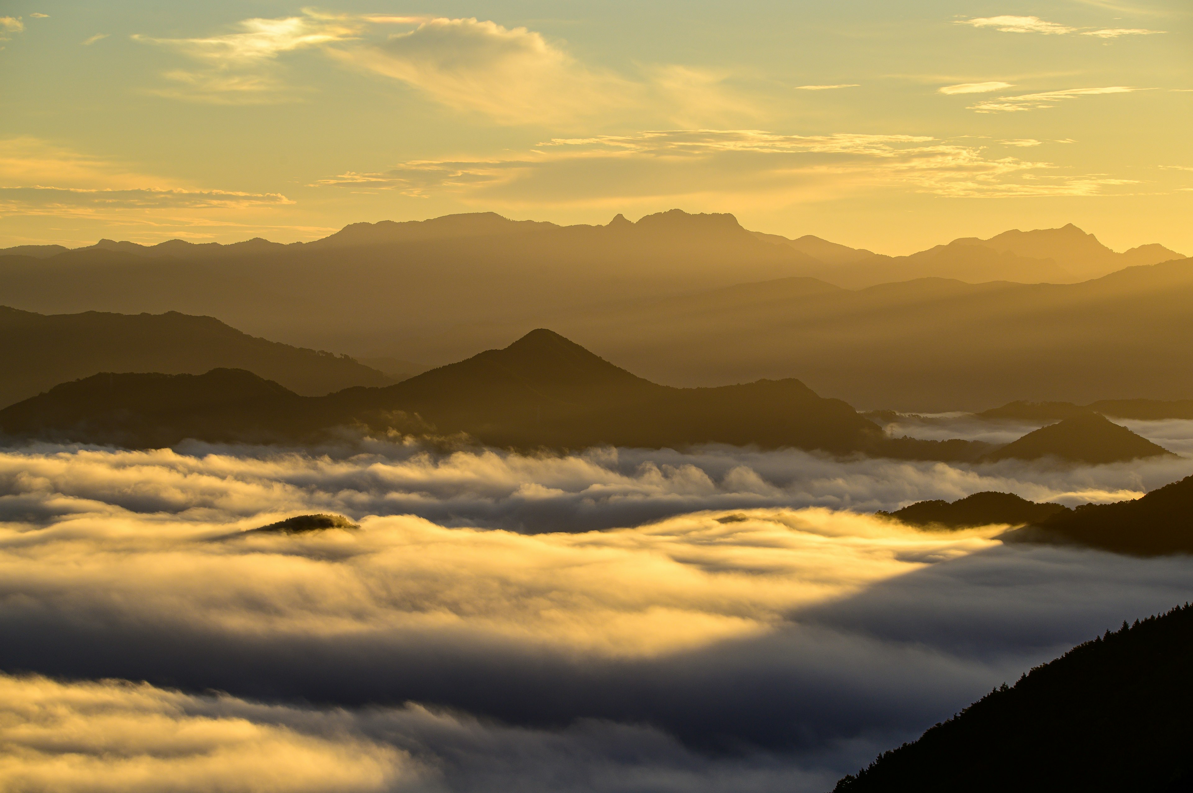 Paisaje montañoso envuelto en niebla con un cielo al atardecer