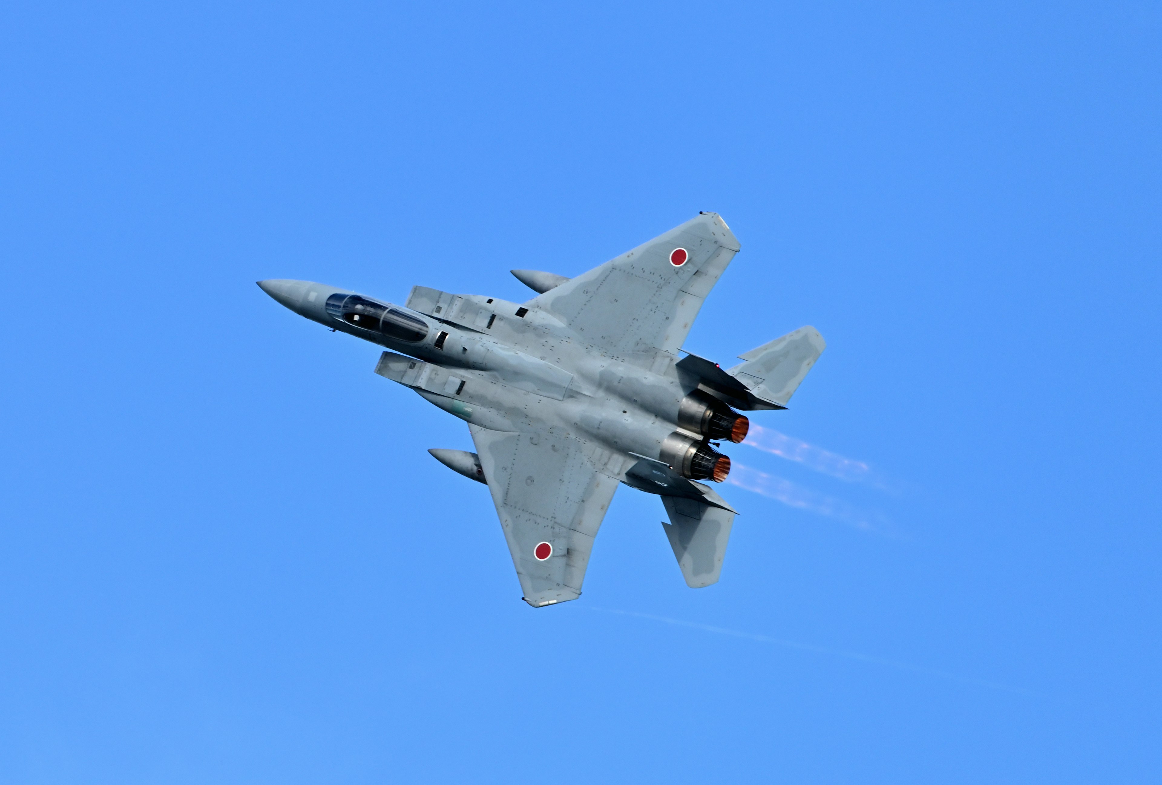 Avion de chasse s'élevant contre un ciel bleu clair