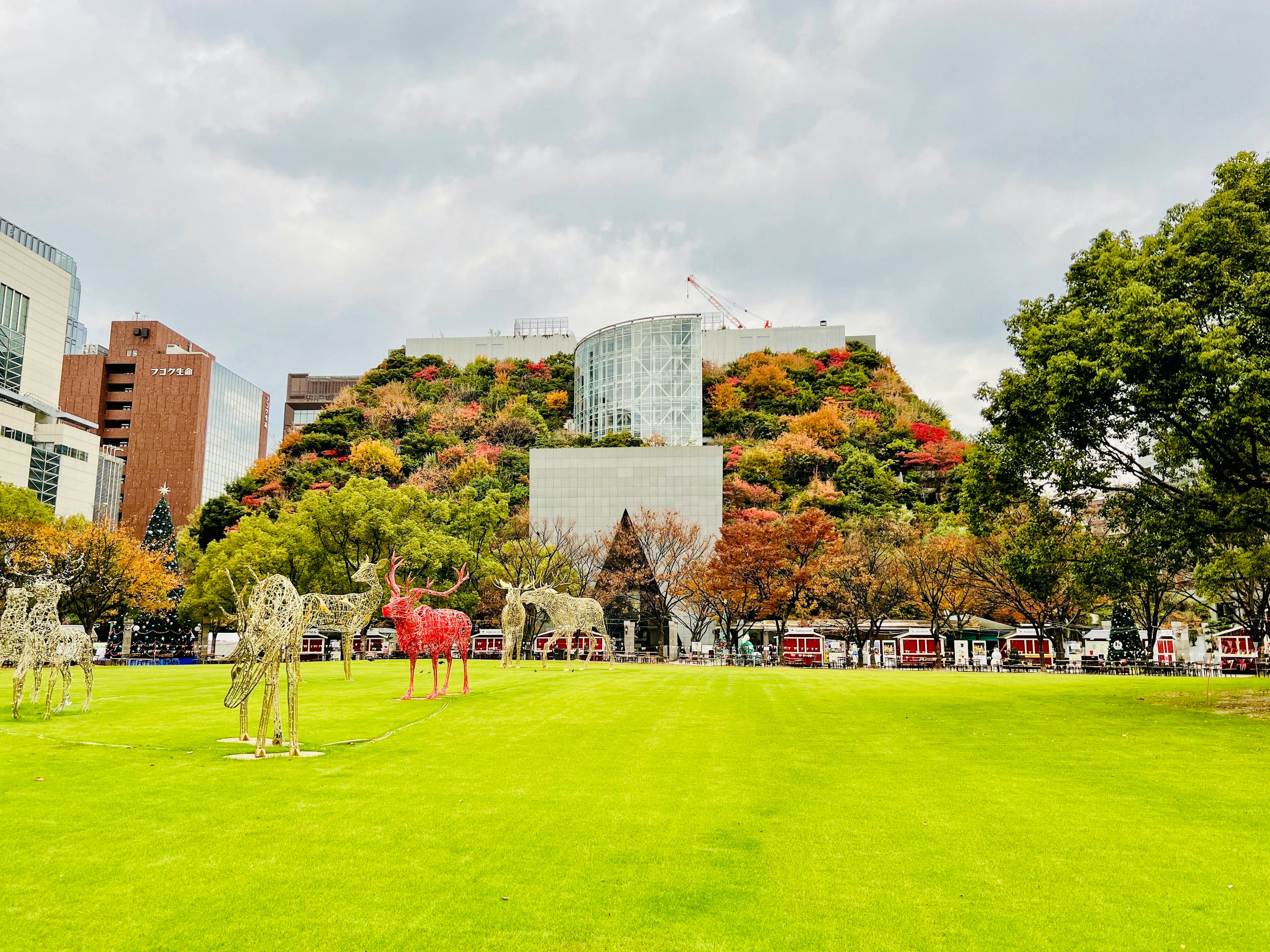 緑豊かな公園に置かれた動物の彫刻と秋の色彩が美しい風景