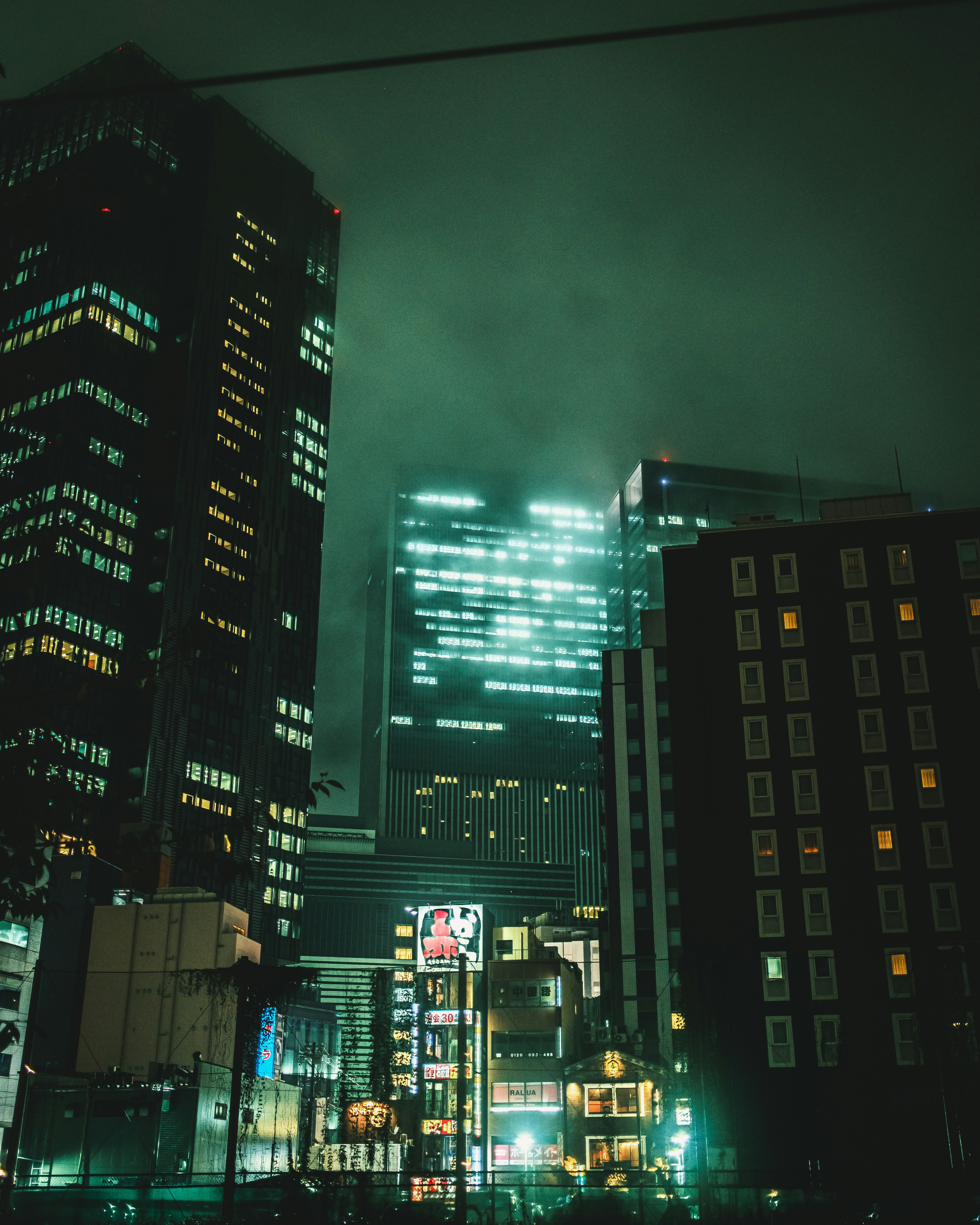 Paysage urbain nocturne avec des gratte-ciel illuminés dans une atmosphère brumeuse