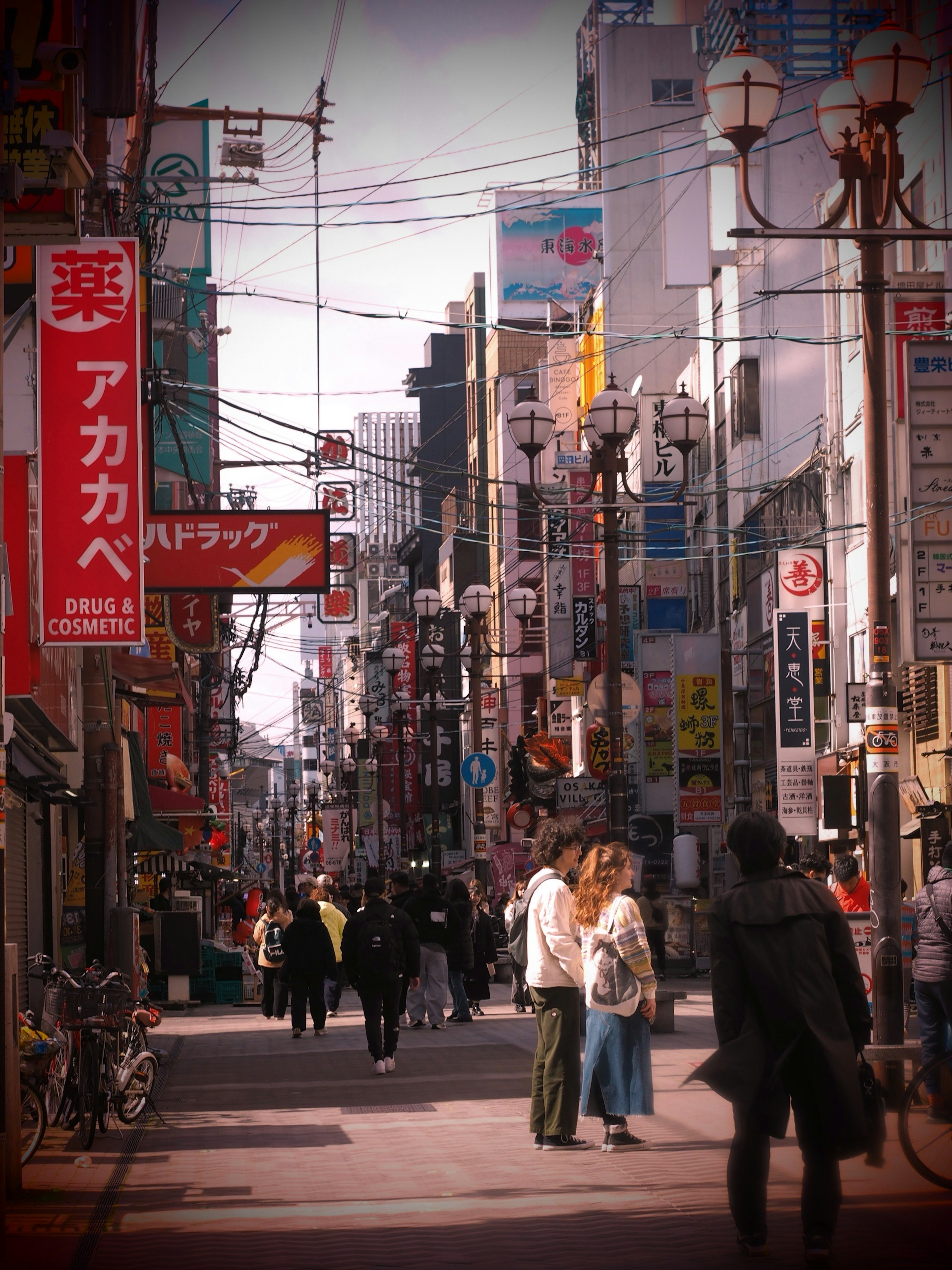 賑やかな都市の通りに立つ人々と色とりどりの看板