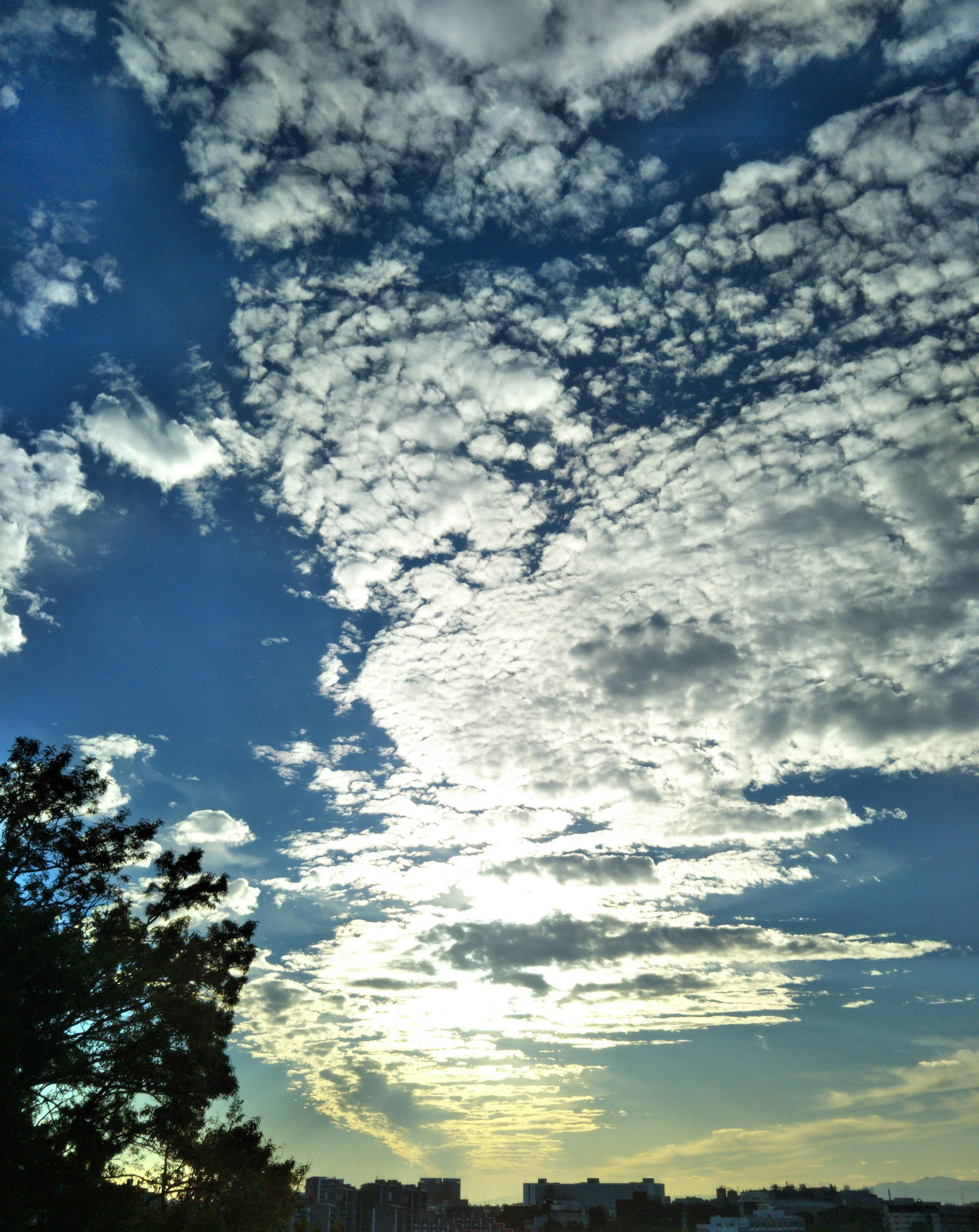 A scenic view of clouds in a blue sky with sunlight shining