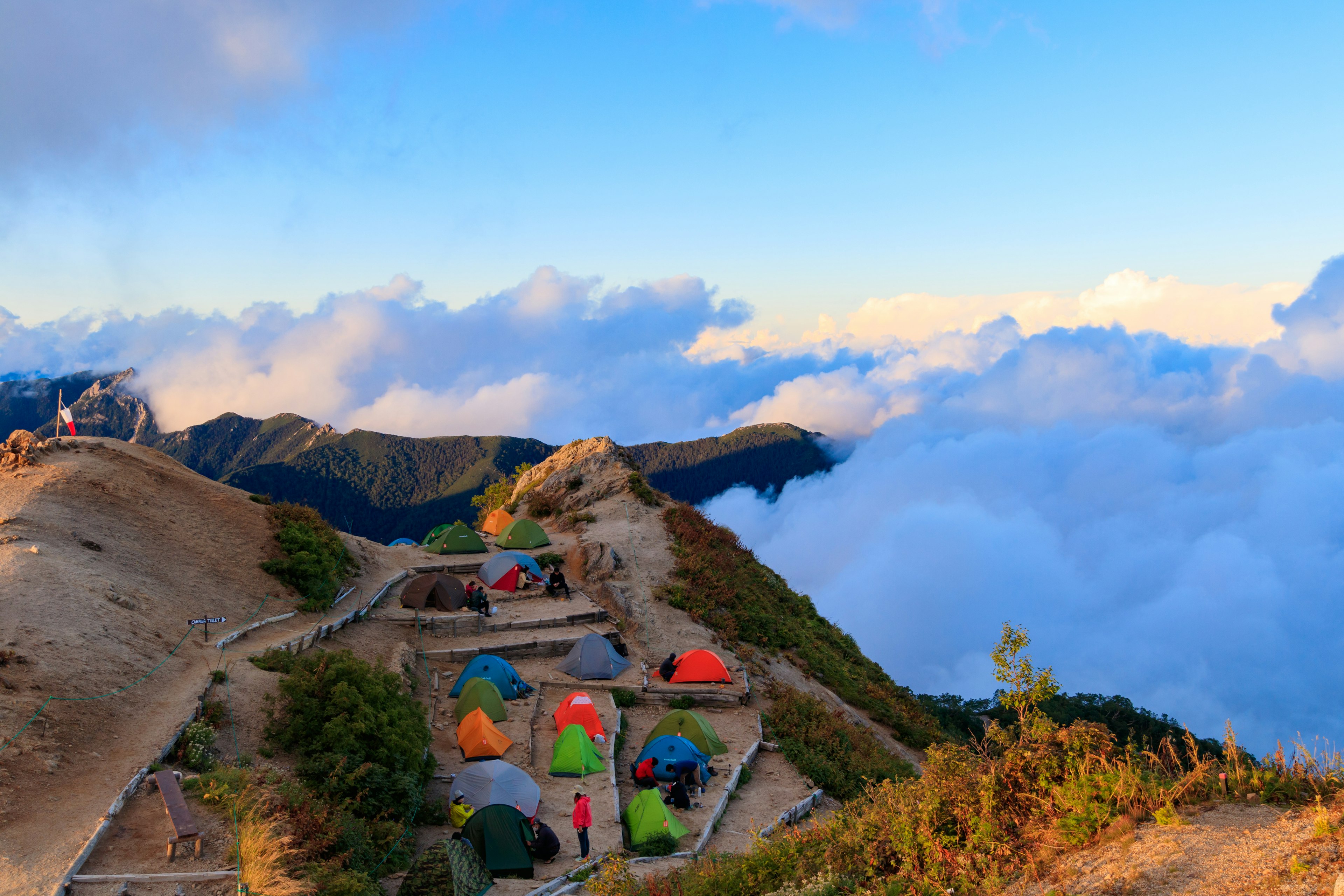 山の頂上にあるカラフルなテントと雲海の風景