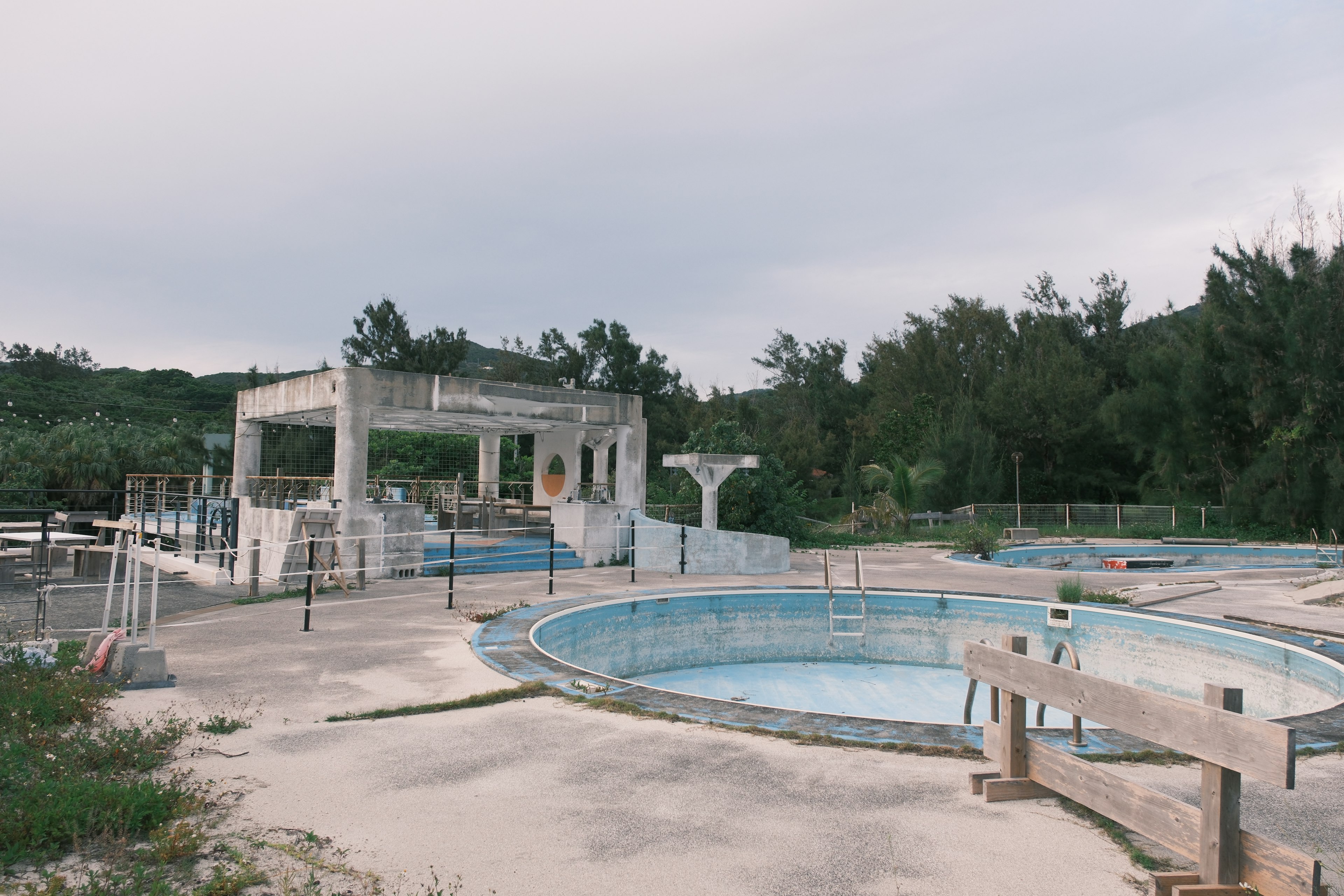 Instalación de piscina abandonada con viejas piscinas y alrededores cubiertos de hierba