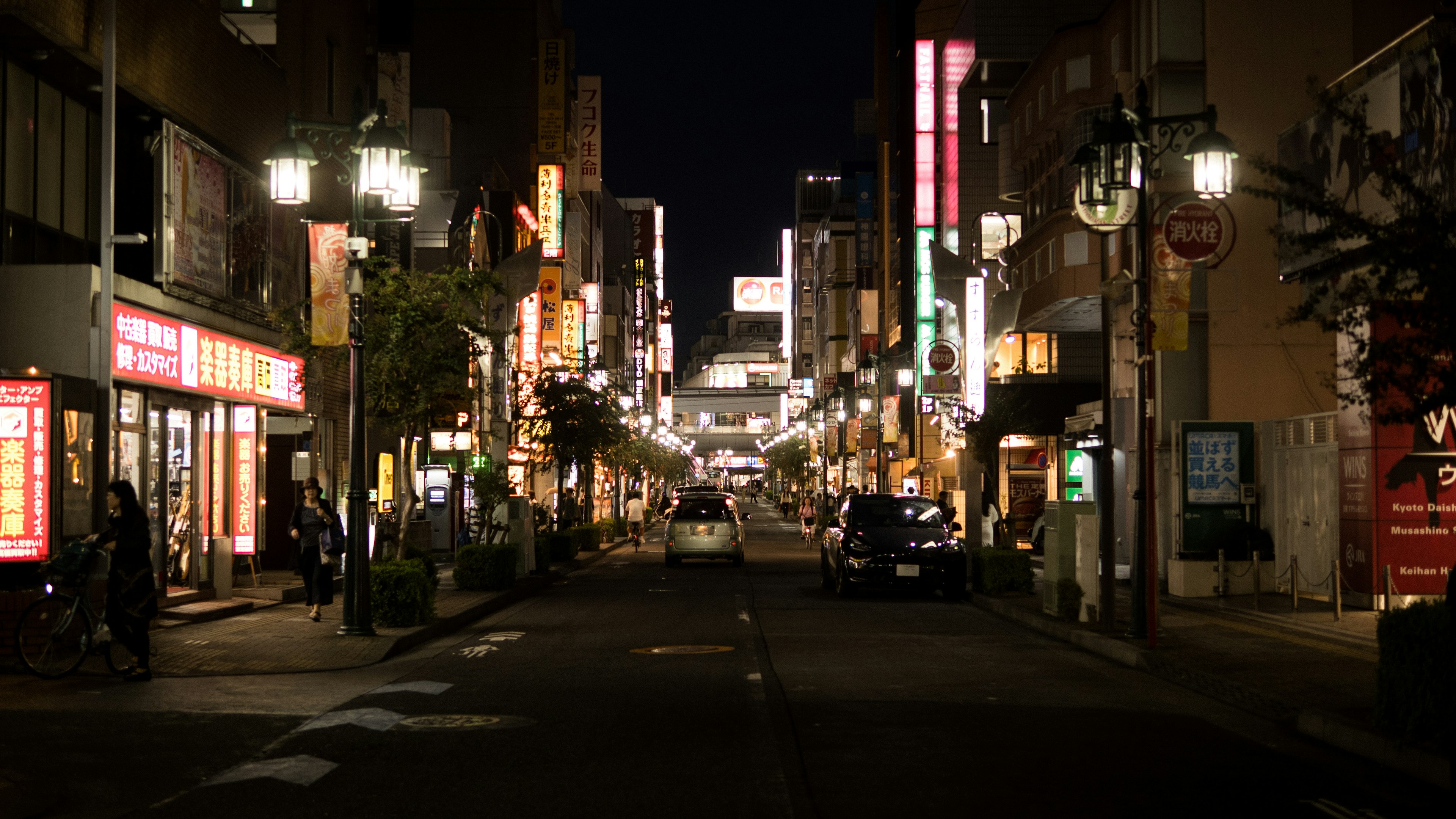 Des enseignes au néon colorées illuminant une rue calme la nuit