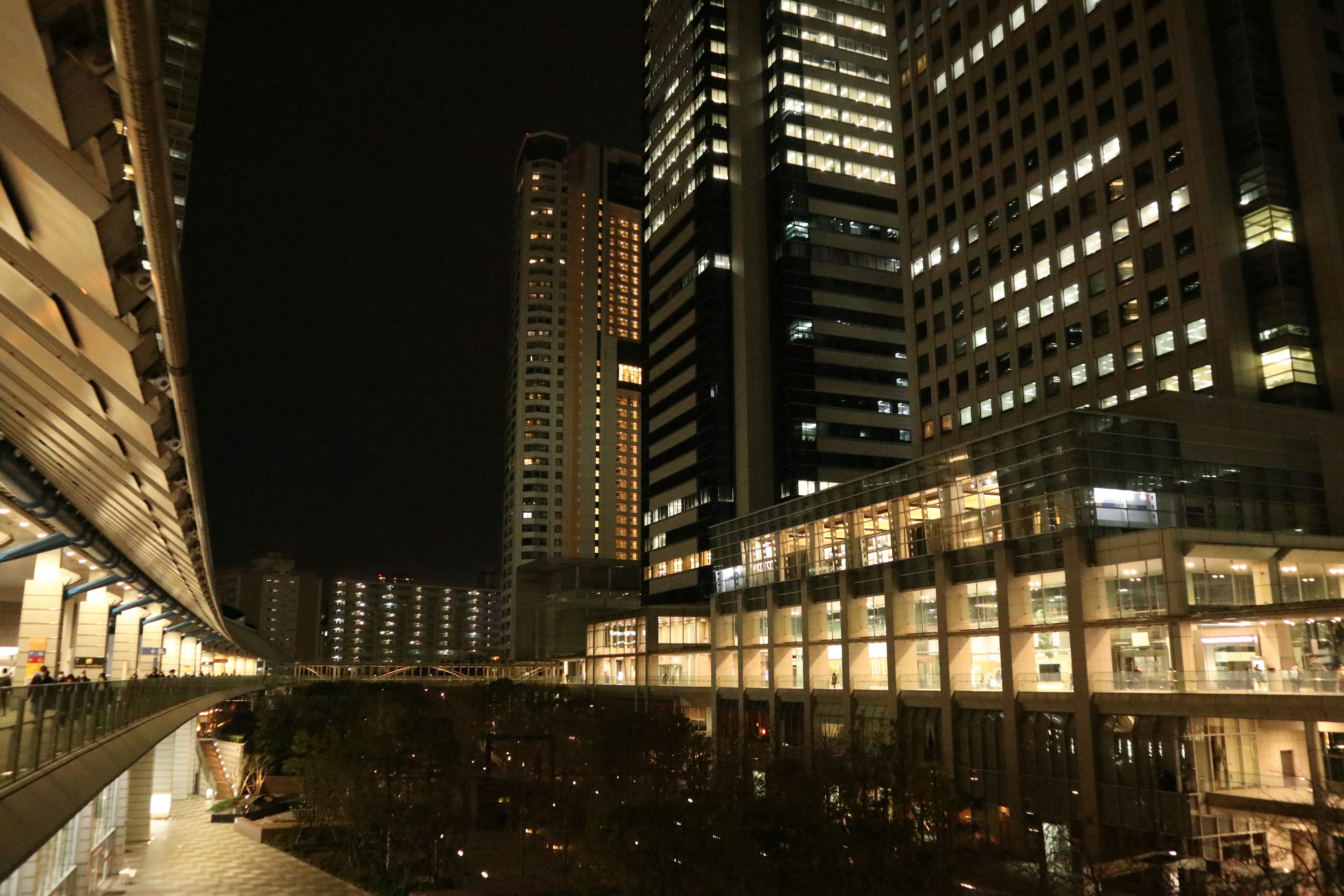 Pemandangan kota malam dengan gedung pencakar langit dan bangunan yang diterangi