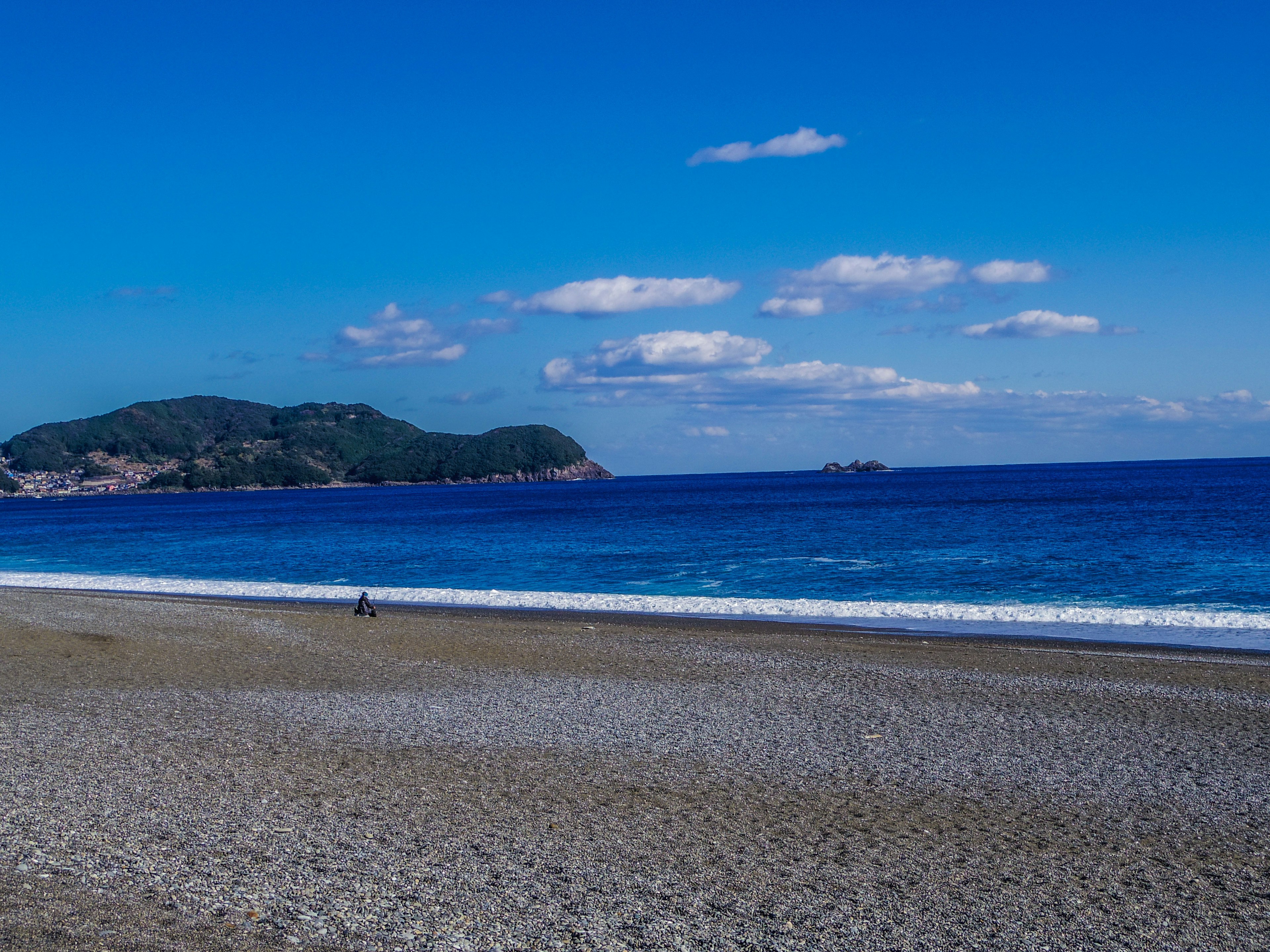 Hermosa escena de playa con cielo azul claro y olas tranquilas isla lejana