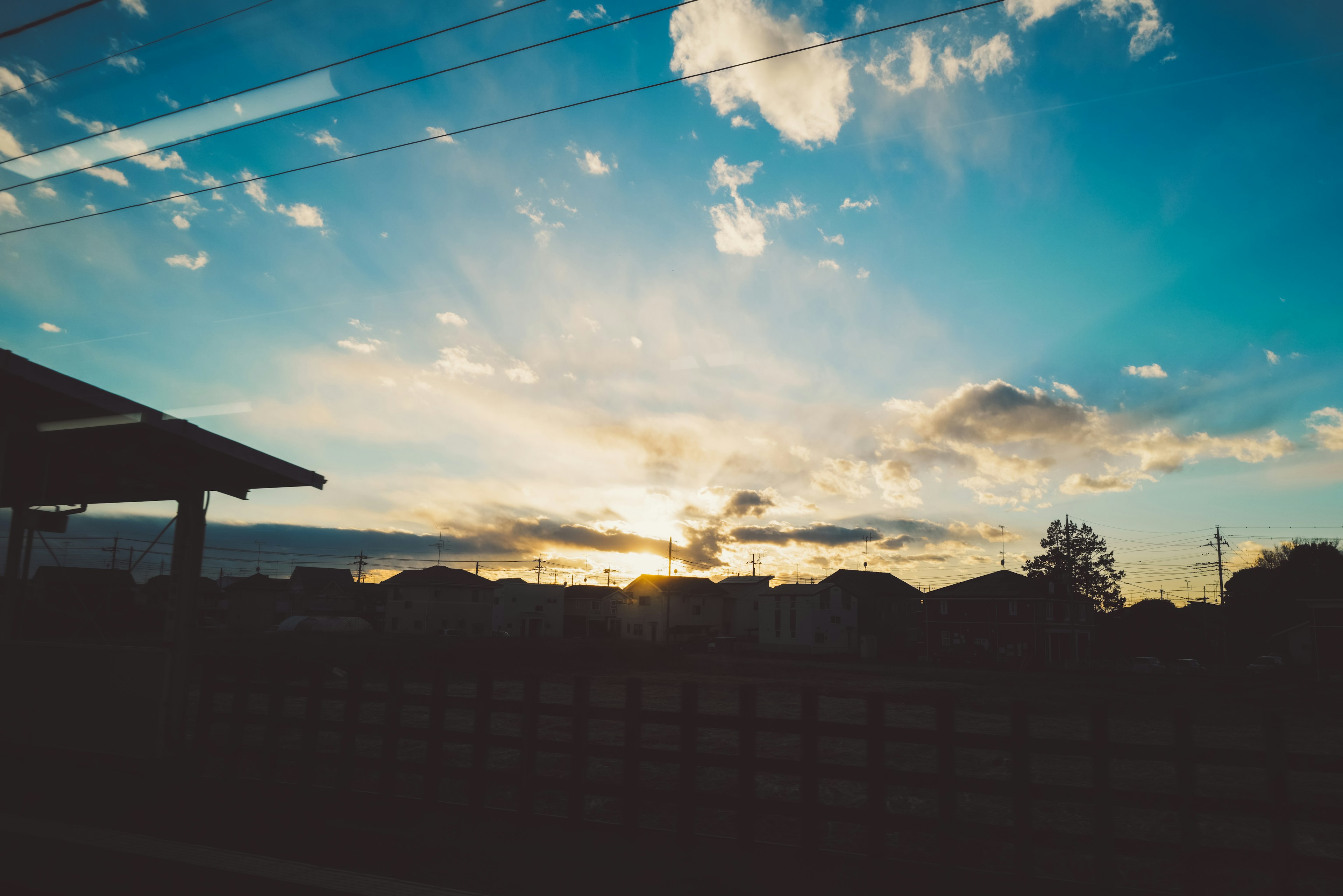 Schöner Sonnenuntergangshimmel mit Wolken von einem Bahnhof aus sichtbar