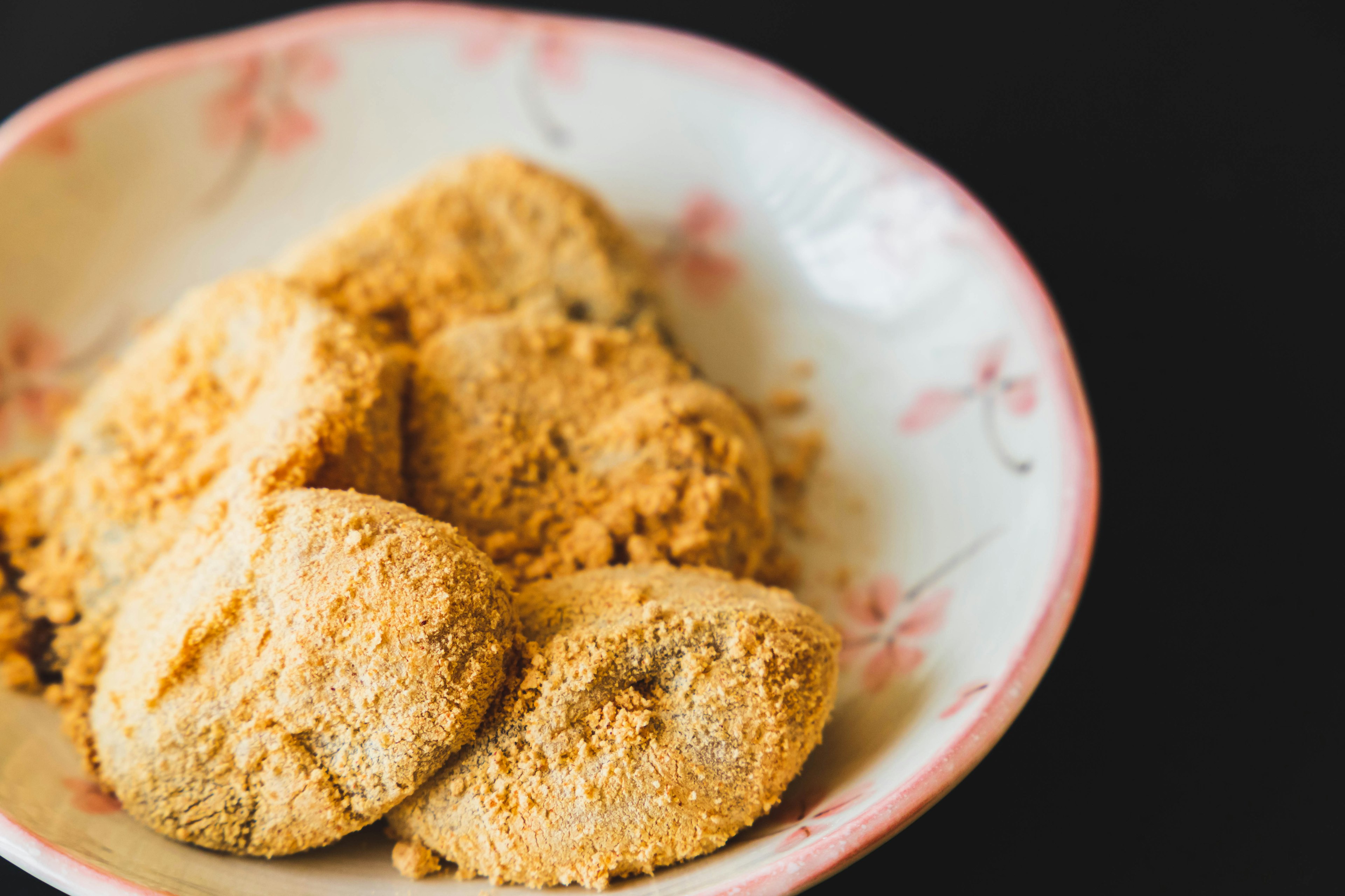 Japanese sweets coated in soybean flour on a decorative plate