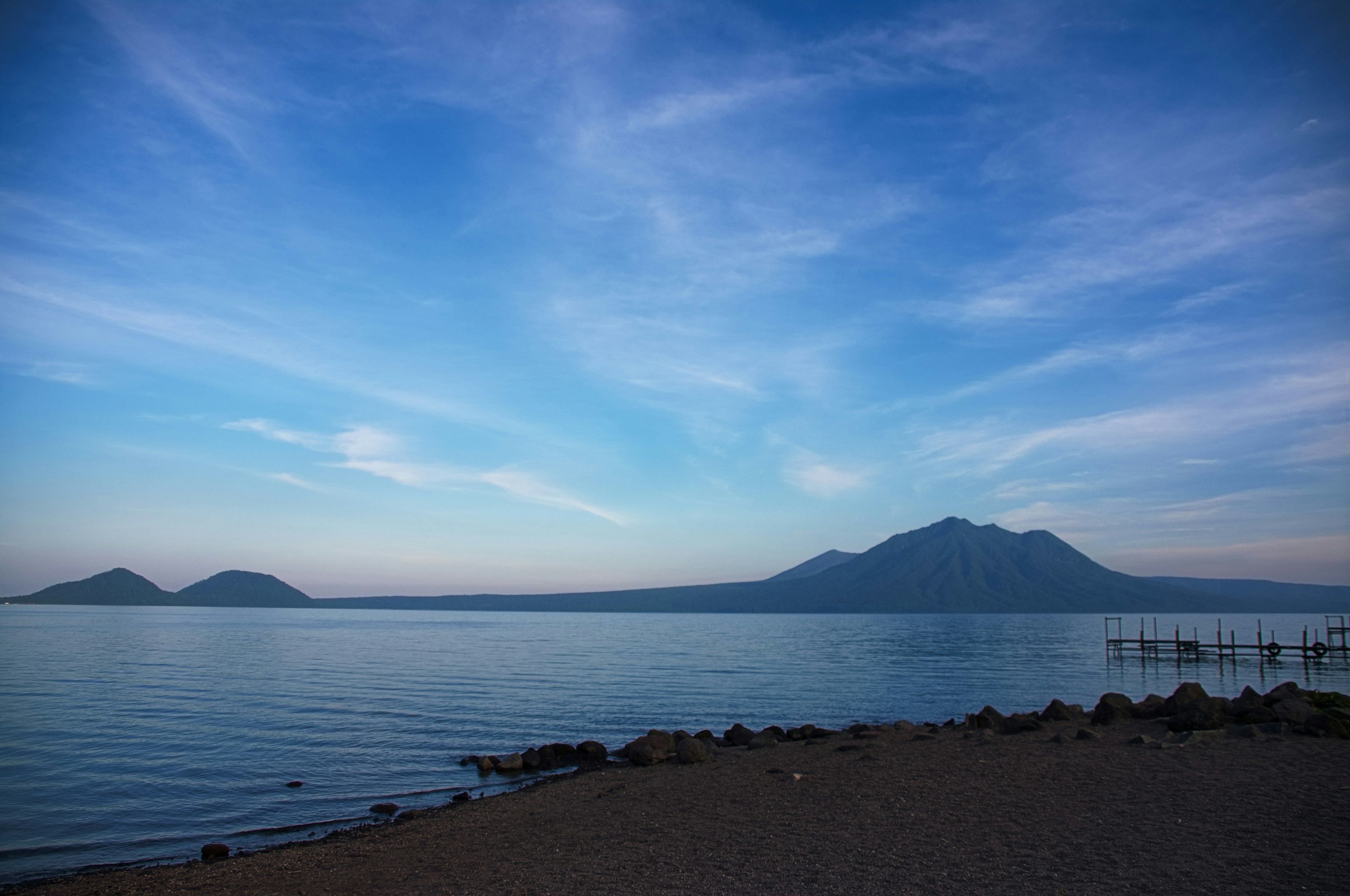 Ruhige Landschaft mit blauem Himmel und ruhigem Wasser mit entfernten Bergen