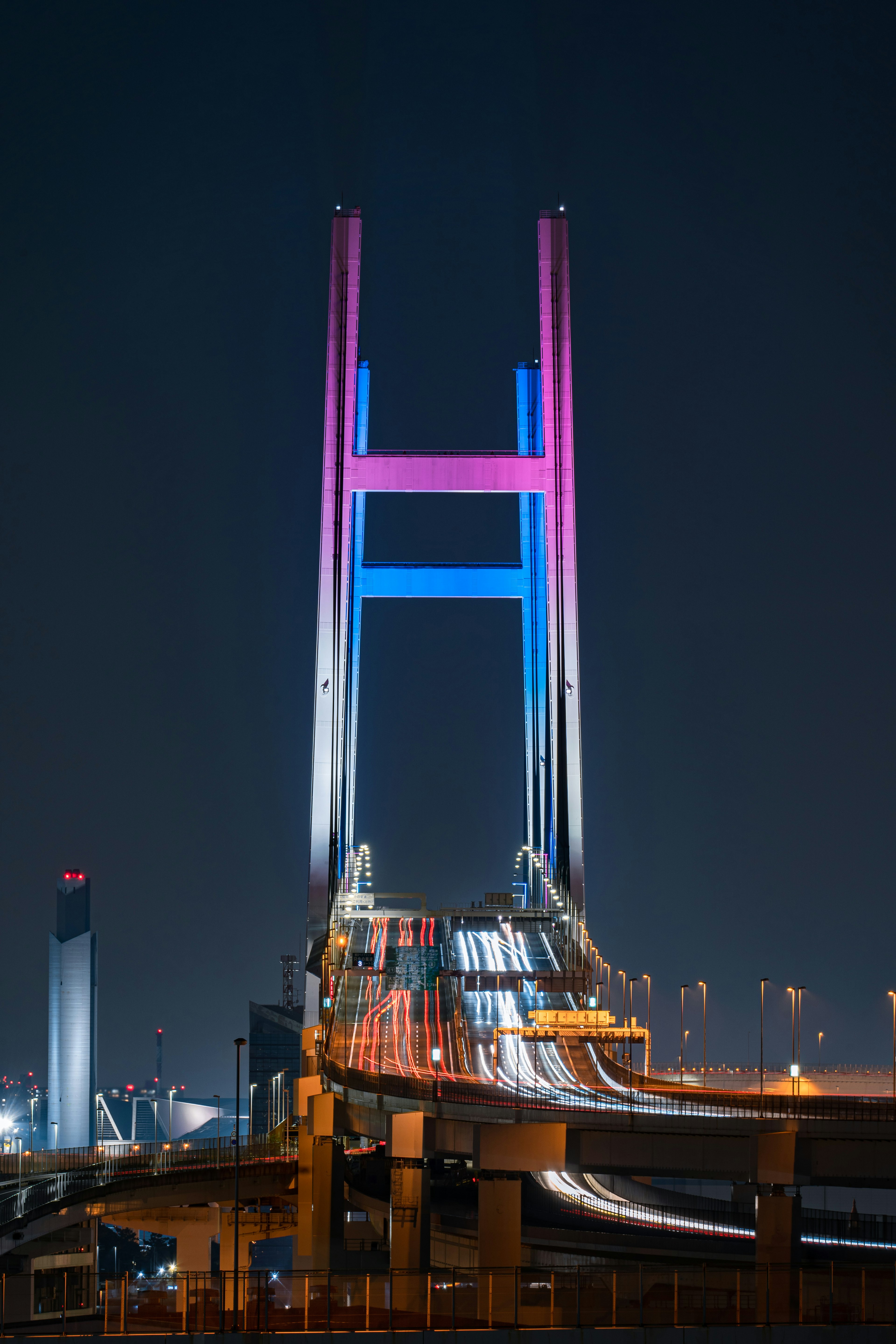 Desain jembatan yang diterangi menunjukkan warna-warna cerah di malam hari