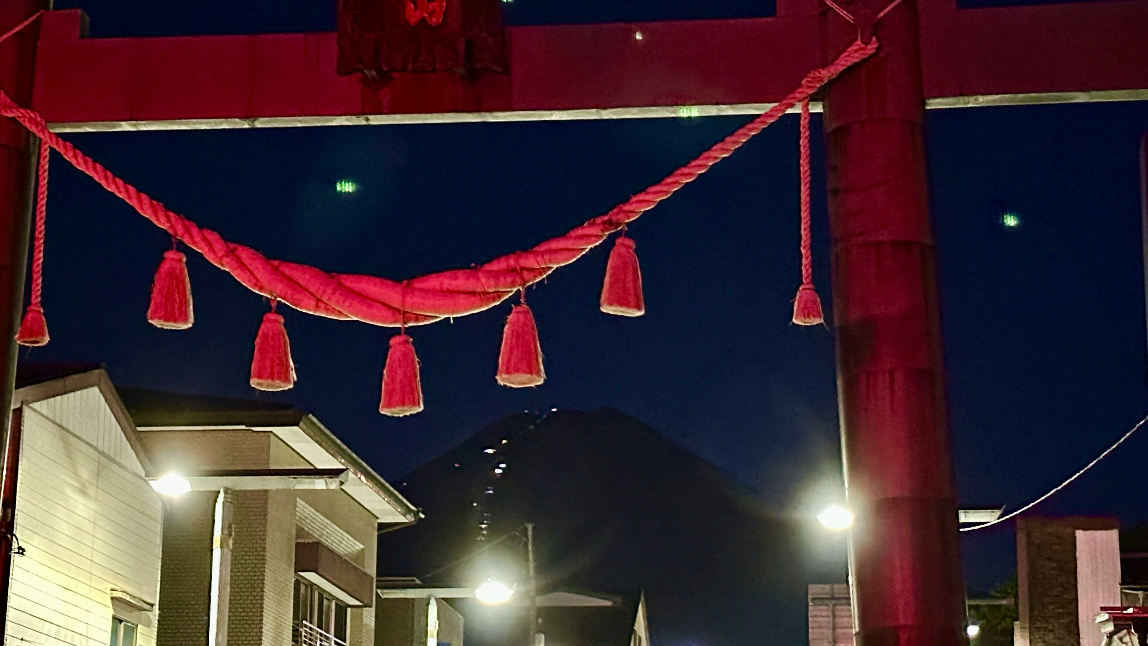 Torii con shimenawa rossa di notte