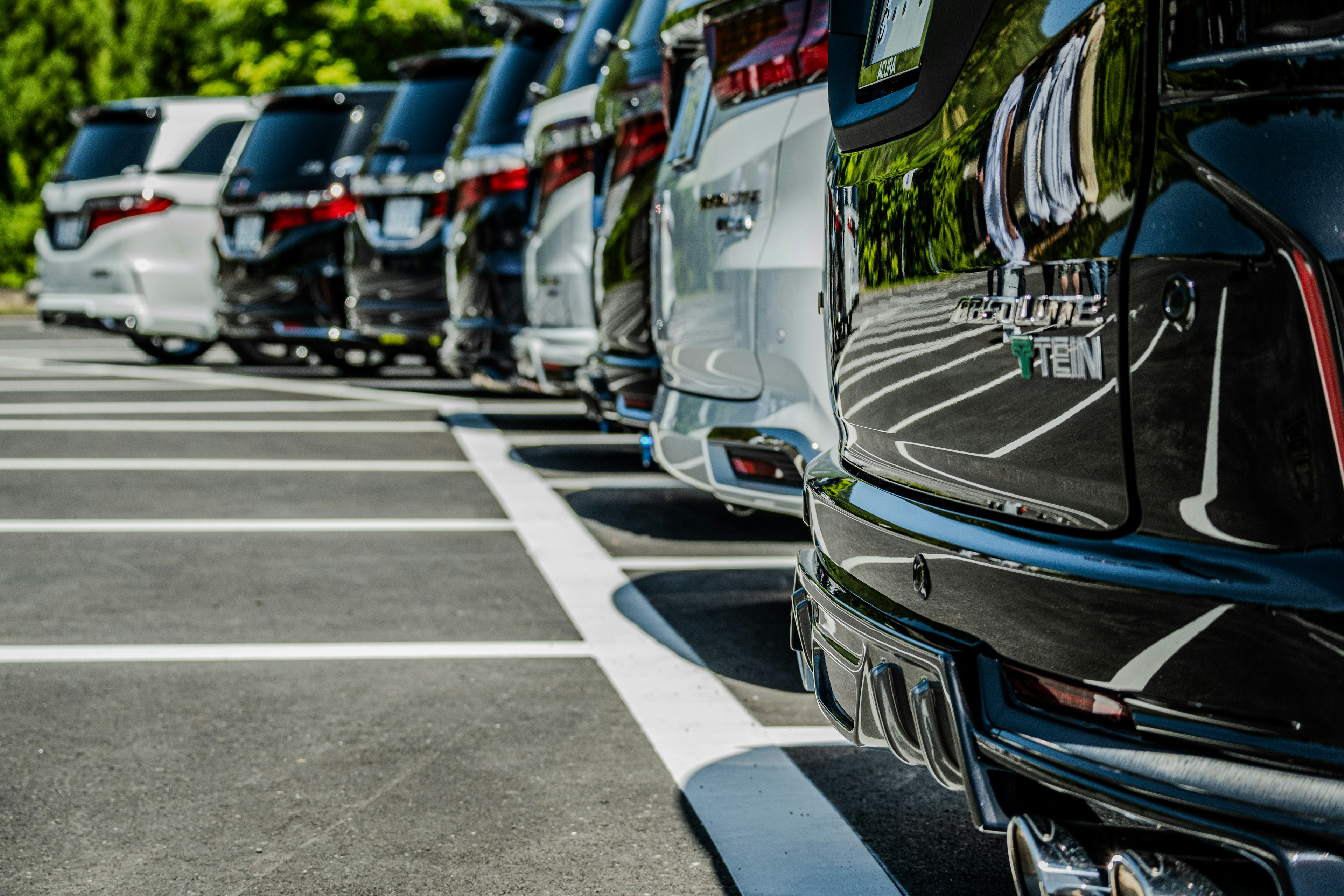 Imagen que muestra las partes traseras de varios coches estacionados en un aparcamiento