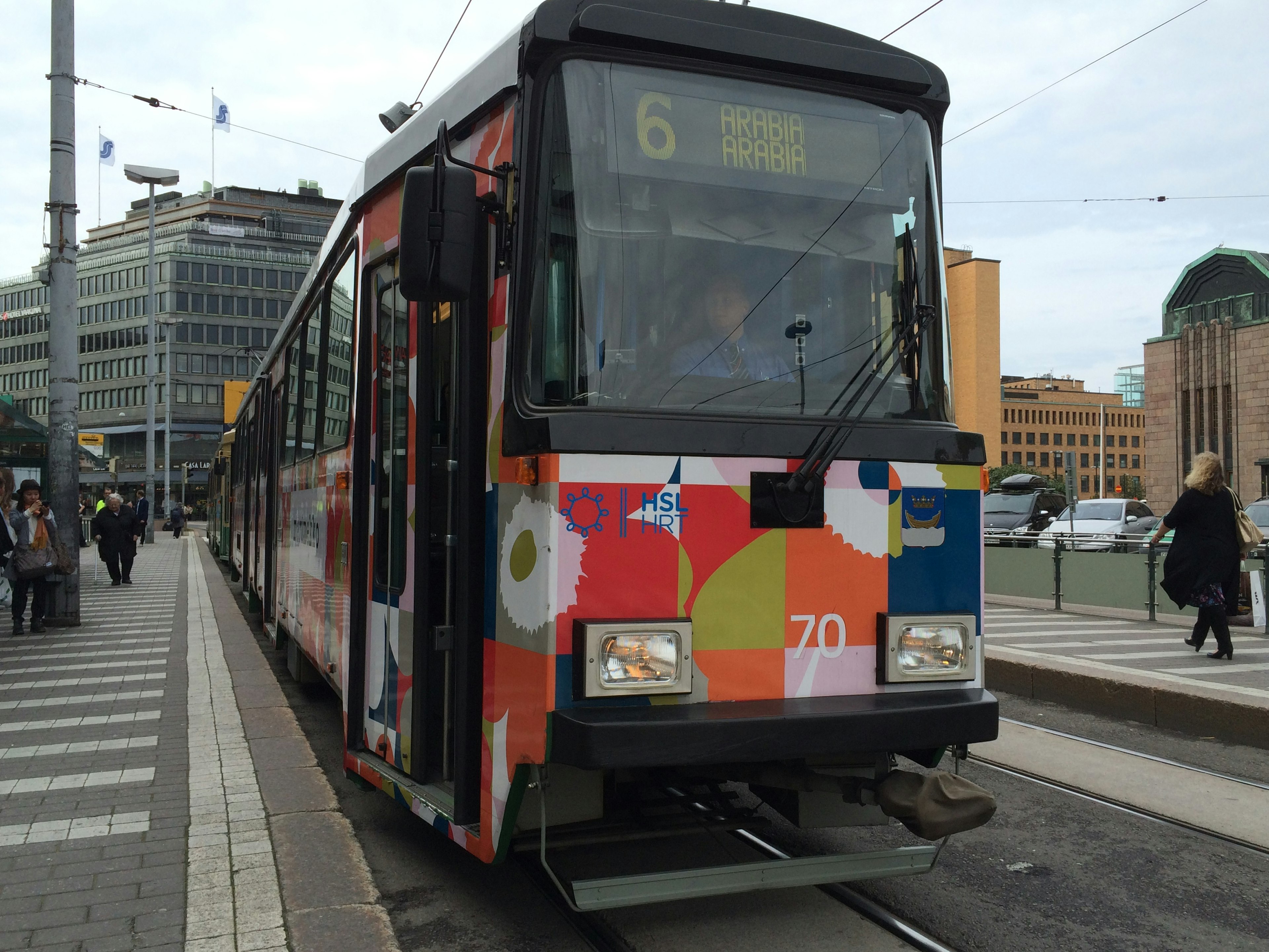 Tram coloré avec un design artistique à un arrêt de la ville