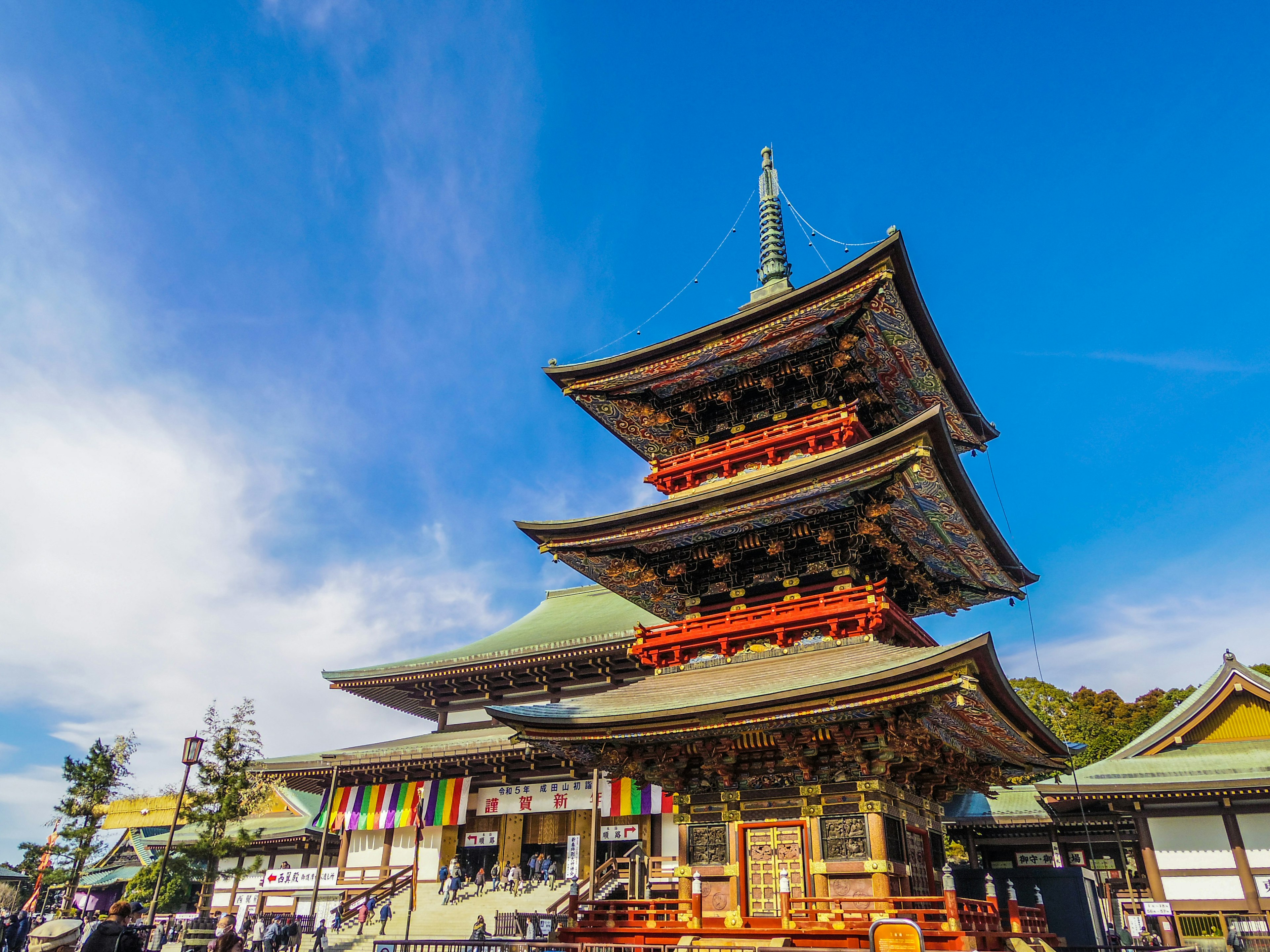 Traditional Japanese pagoda with vibrant decorations under a clear blue sky