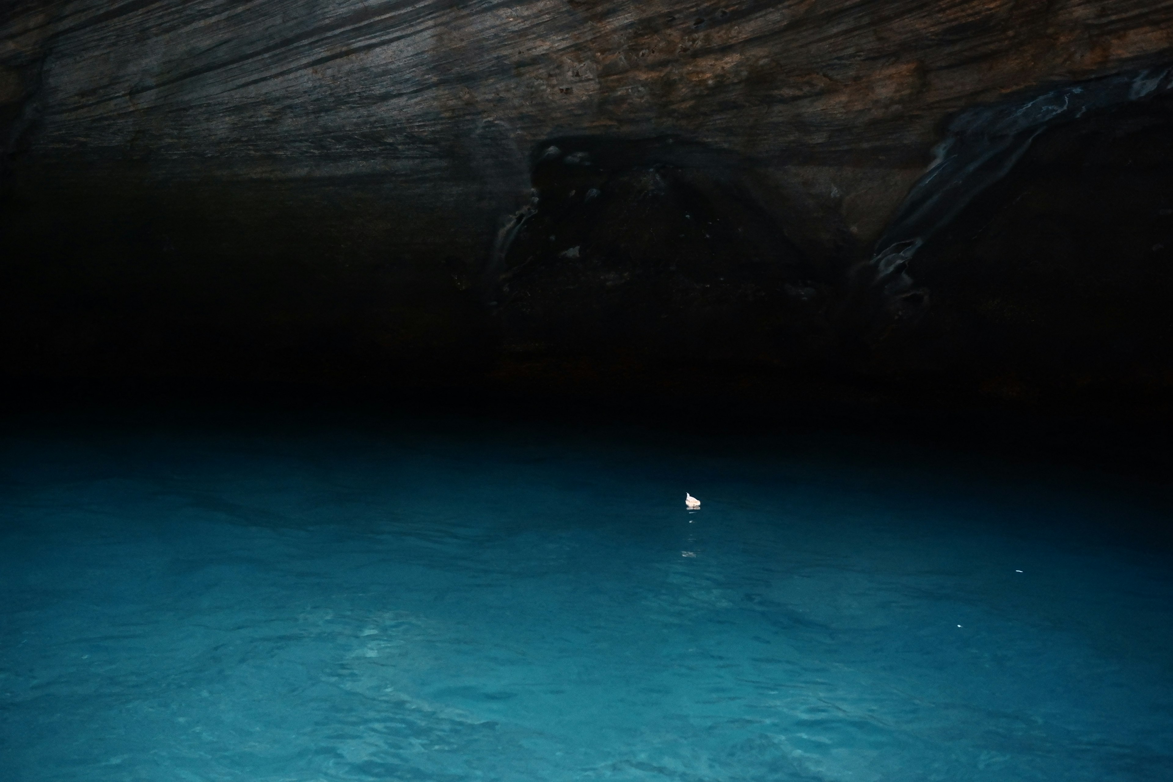 Bild eines Höhleninneren mit weitläufigem blauen Wasser