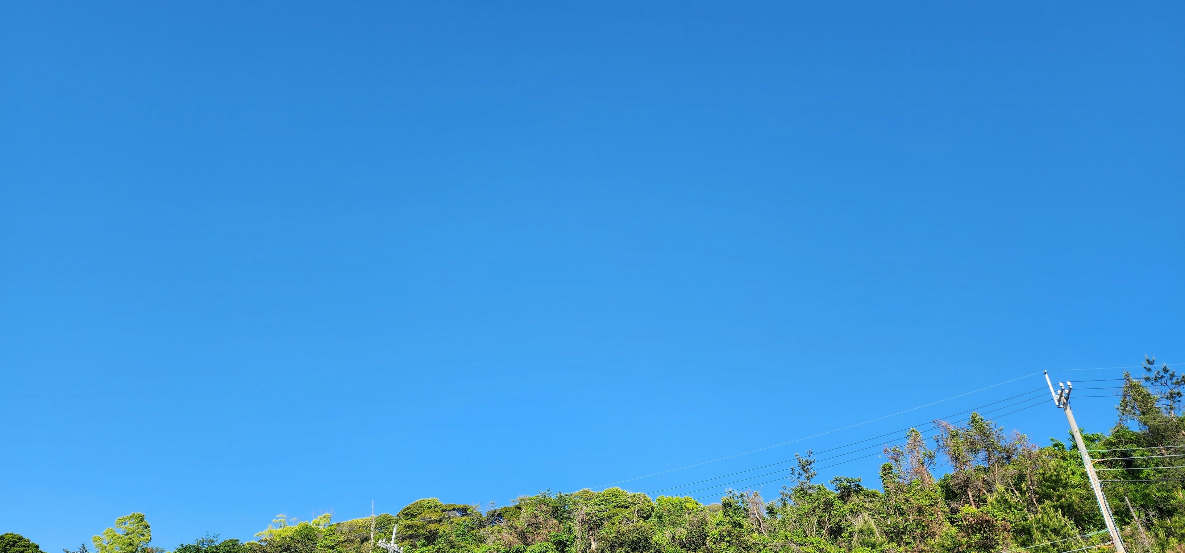 Heller blauer Himmel über grünen Hügeln